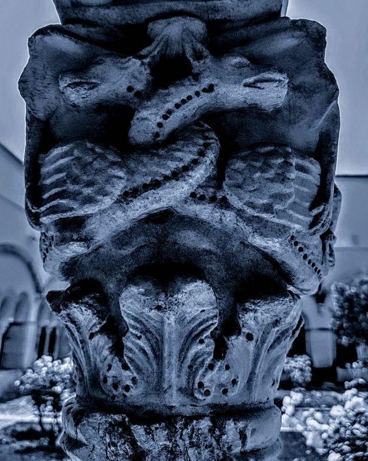 --- union ---
The image shows an intricately carved stone column with decorative elements resembling foliage and possibly animal figures. The details are quite elaborate, featuring patterns and textures typically found in architectural ornamentation. The background appears to be an outdoor setting, likely part of a historical or cultural site.