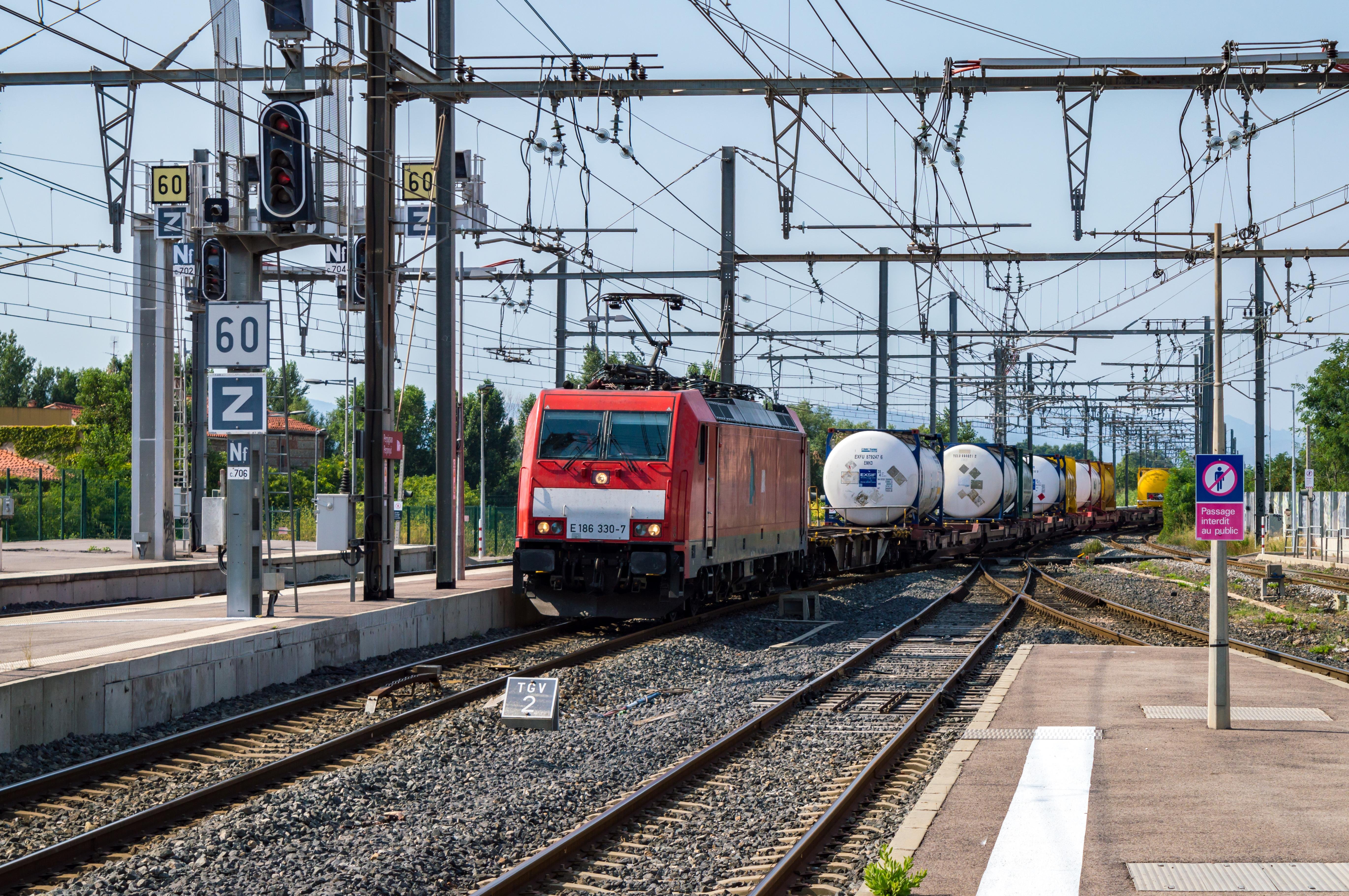 Freight train pulled by a Traxx locomotive passes through Perpignan station