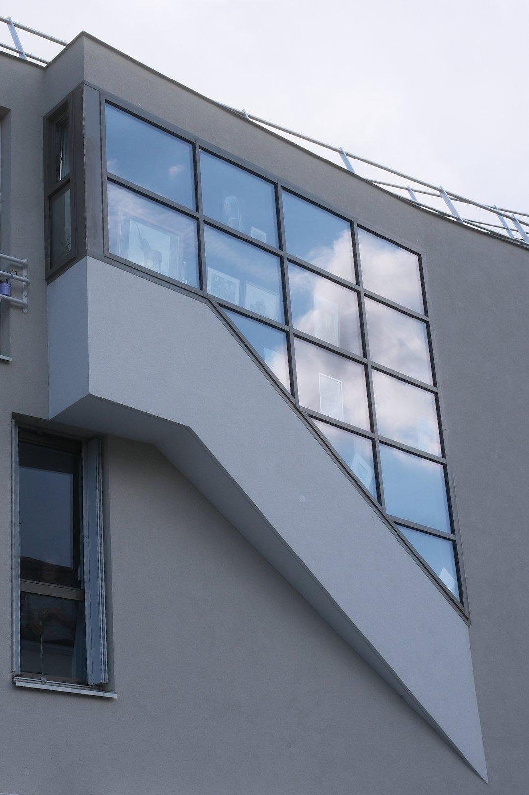 Un bâtiment avec une excroissance avec une baie vitrée (sûrement des escaliers)