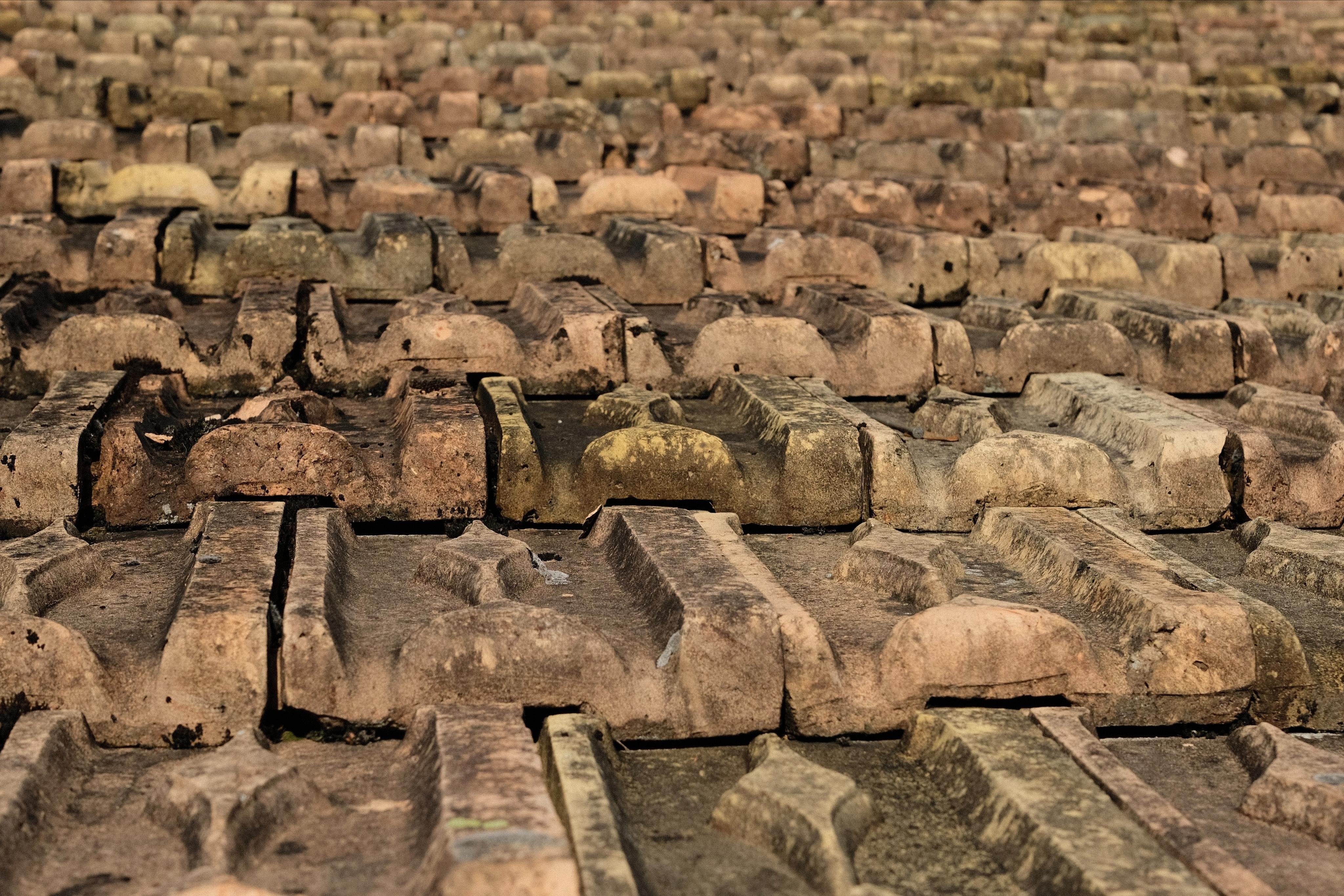 Rows of weathered rooftop tile with a rugged texture, tightly packed and receding into the distance, filling the frame.