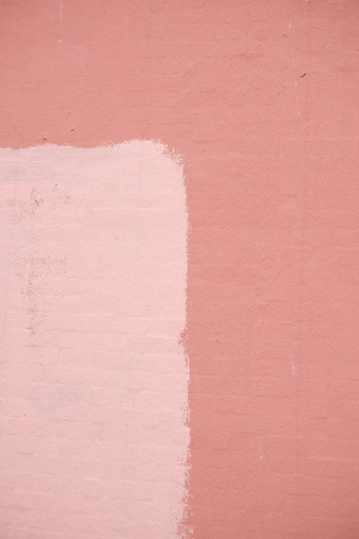 Photo verticale. Un morceau de mur couleur saumon et rose dans le coin inférieur gauche