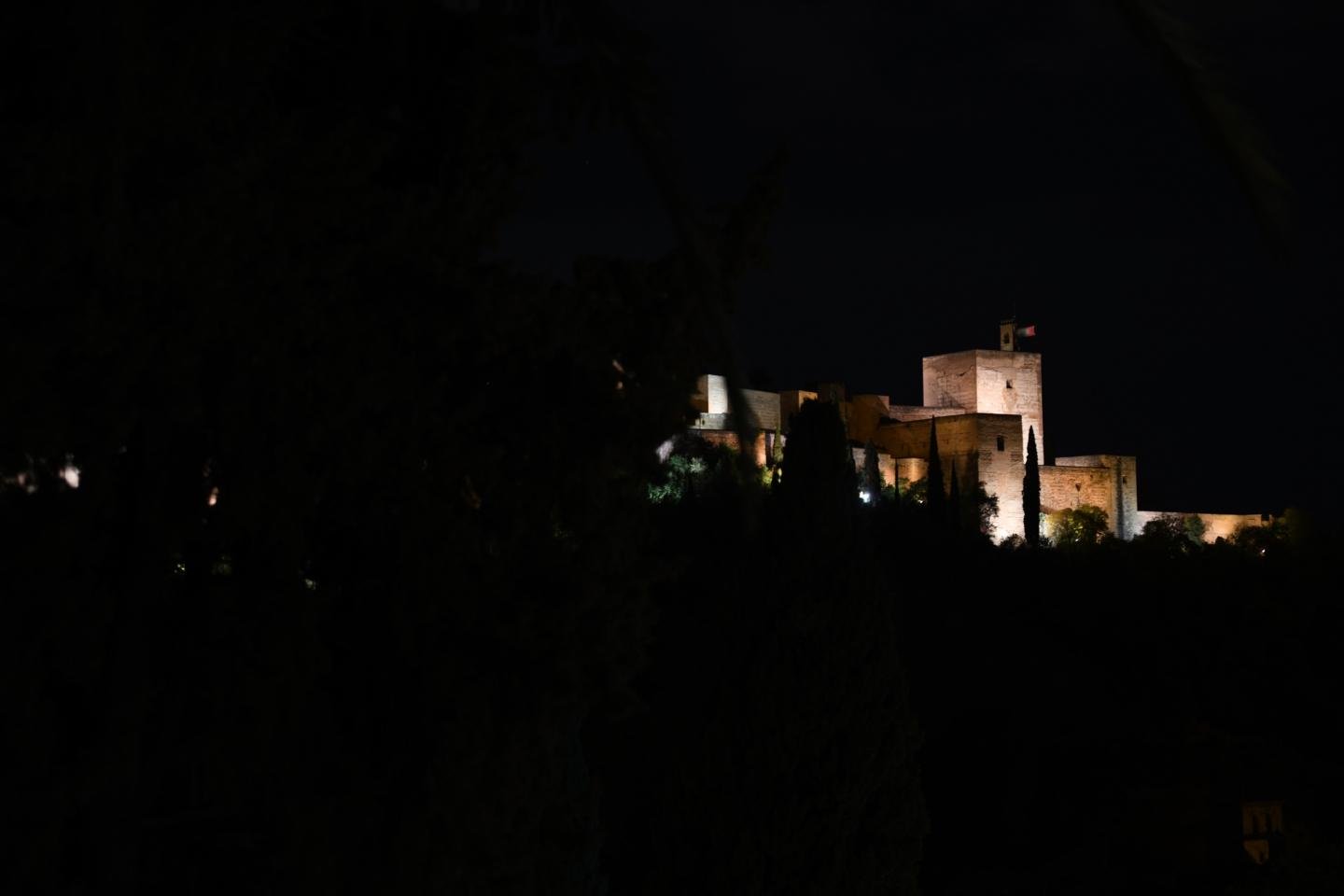 La Alhambra de Granada vista desde el Albaicín una noche de Semana Santa. Todo muy oscuro menos lo iluminado artificialmente.