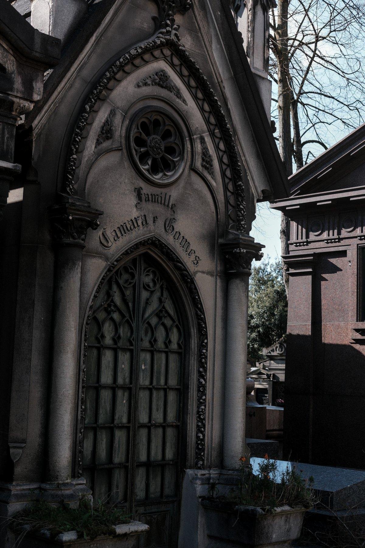 Photo verticale. Un mausolée d’architecture gothique, avec les lettres de la famille enterrée ici en typographie ancienne