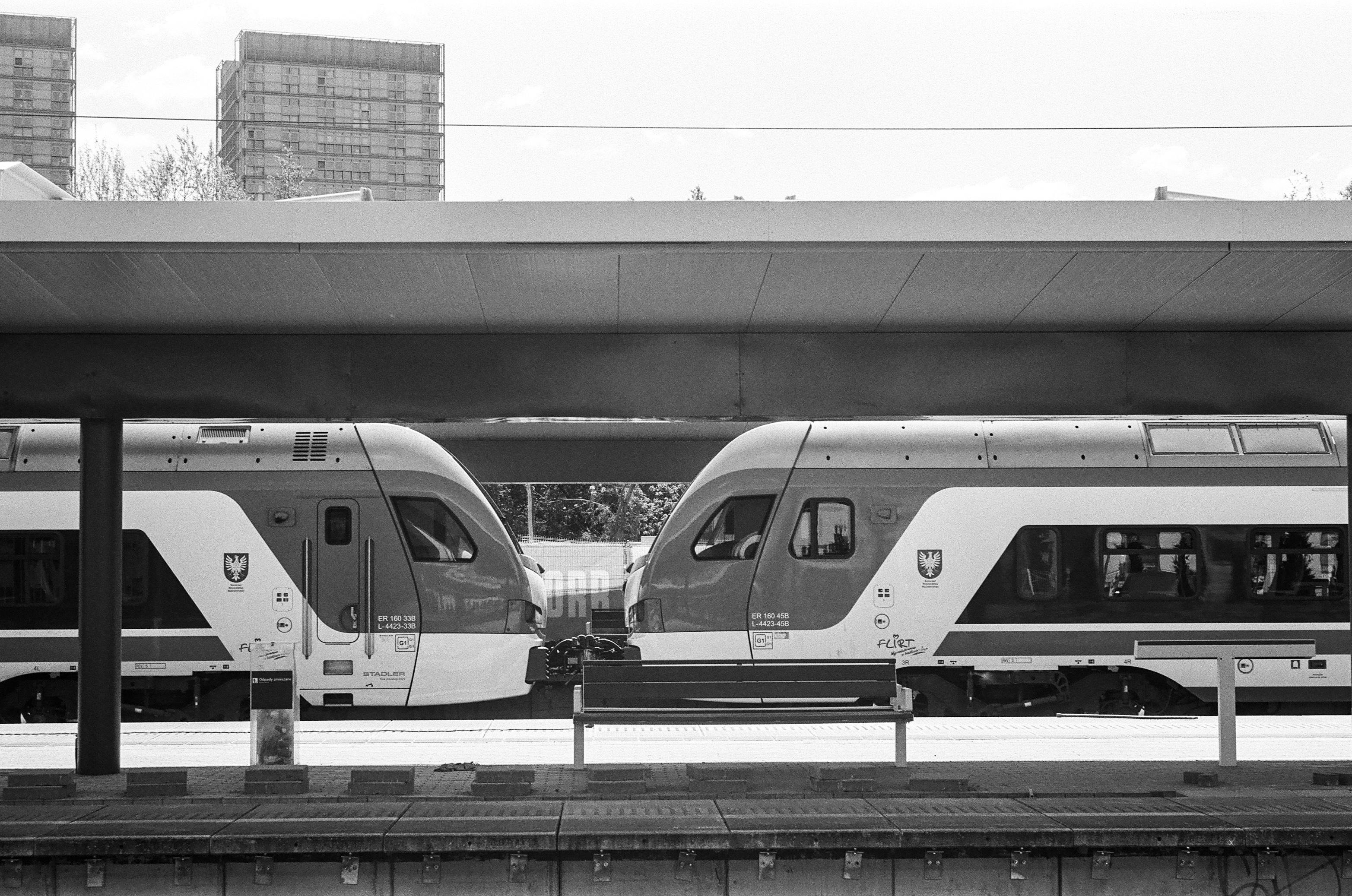 B&W film photo of two Stadler Flirt3 EMUs of KM at Warszawa Gdańska station