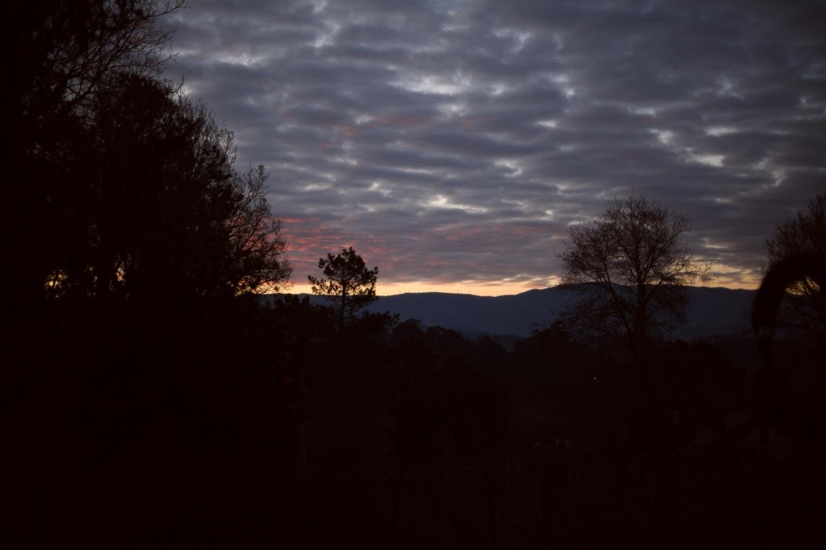 Un amanecer con nubes altas y tonalidades rojizas.