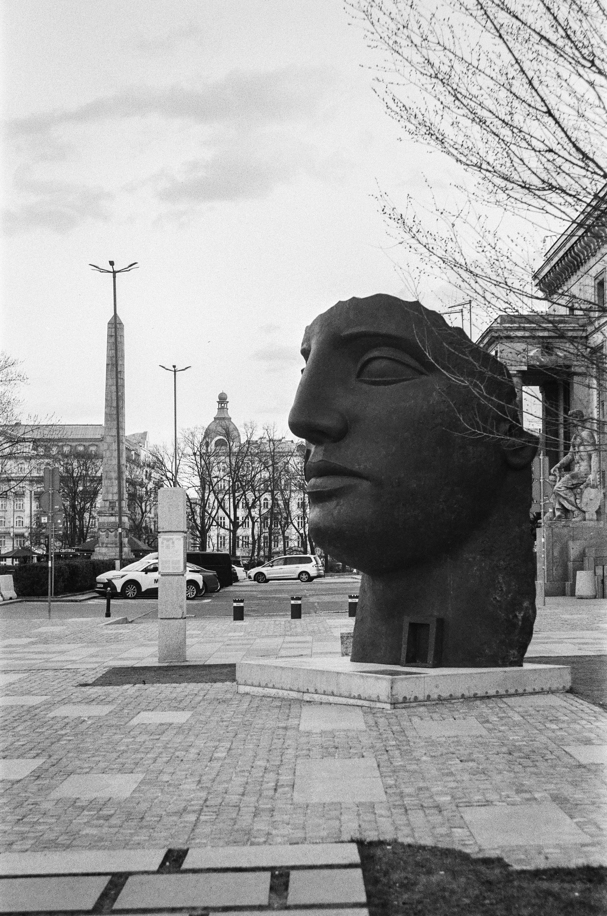 Statue of a face next to Palace of Culture in Warsaw