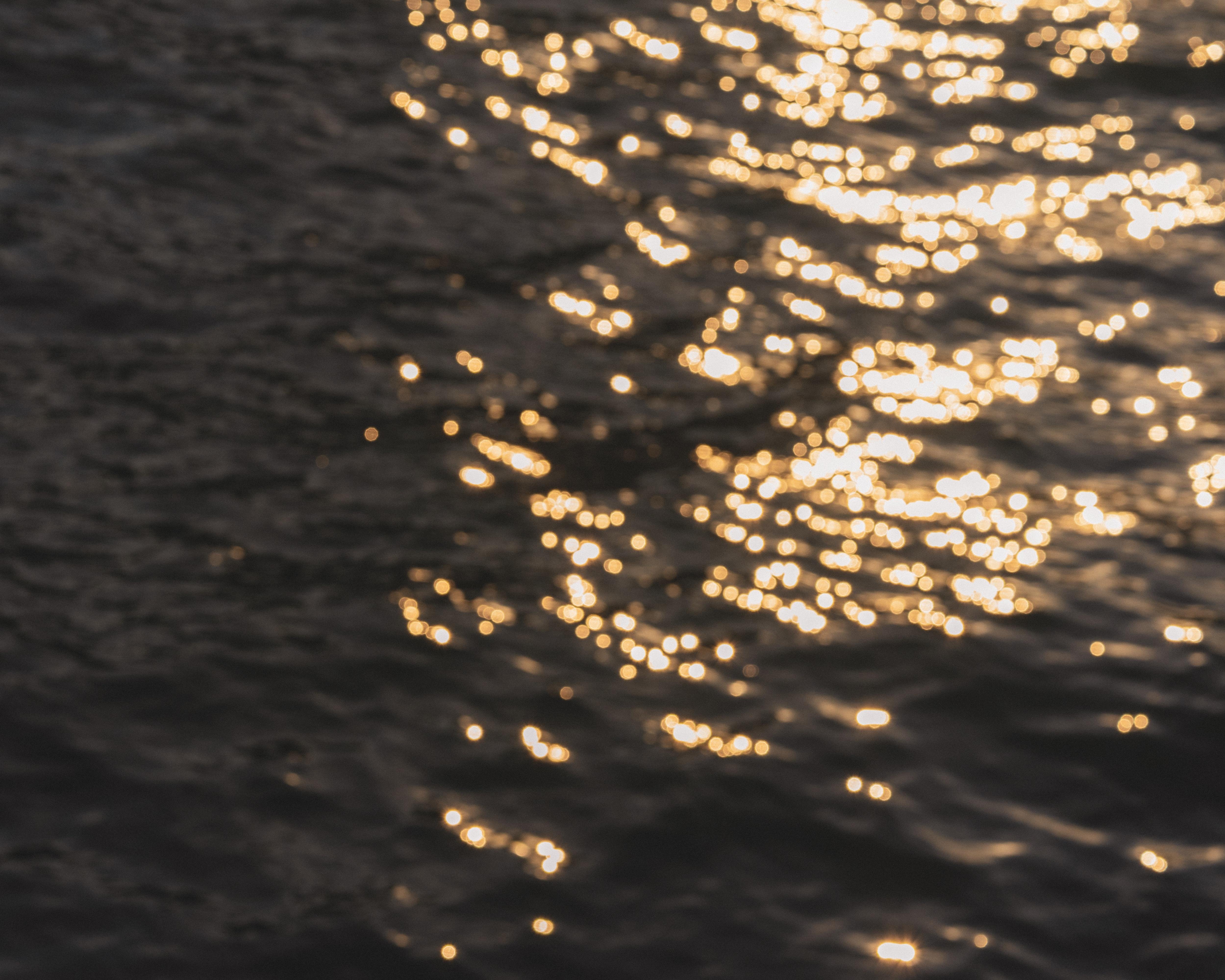 The image shows sunlight reflecting on the surface of water, creating a shimmering effect.