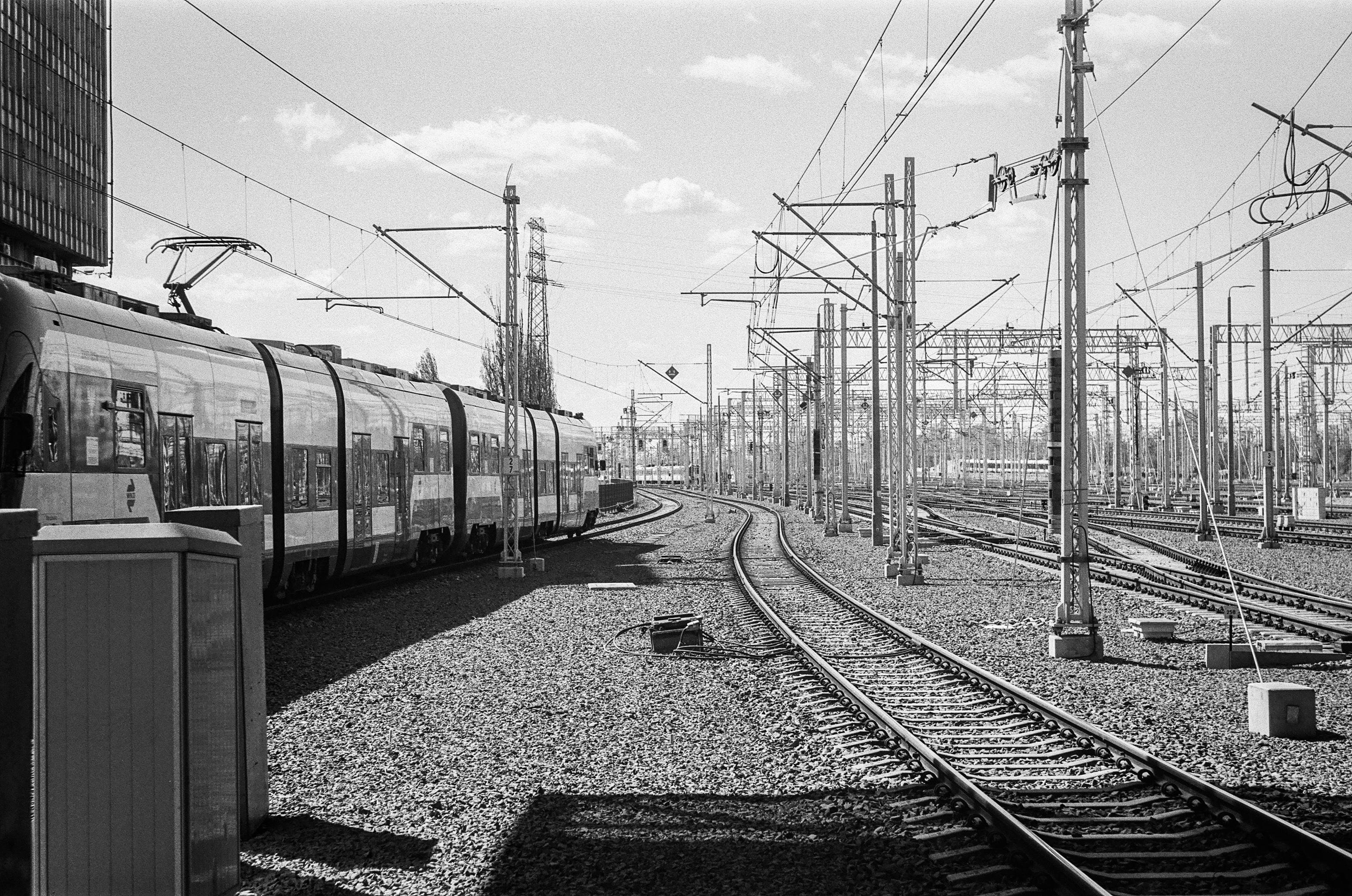 B&W grainy film photo of a WKD train departing from Warsaw West station
