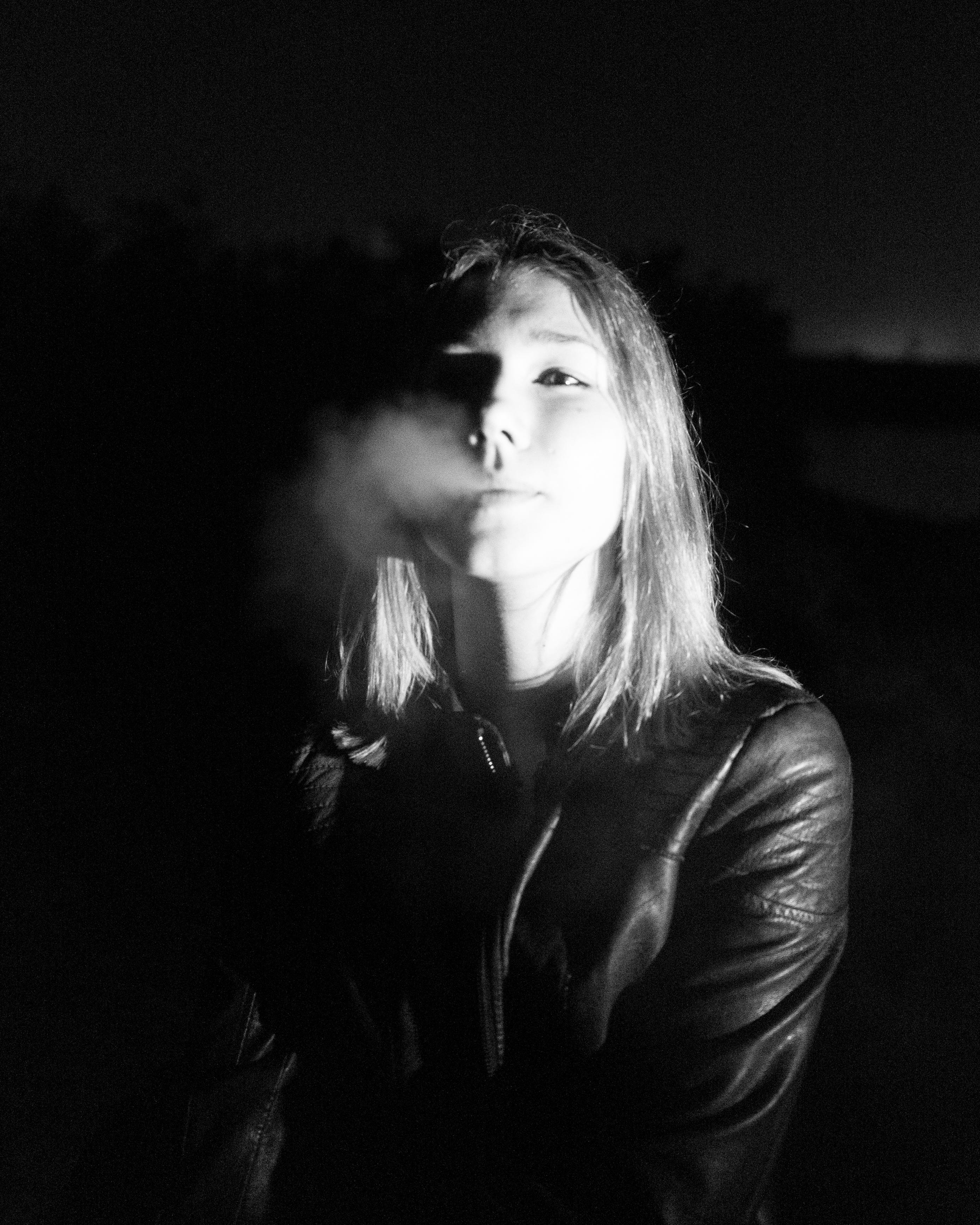 a girl in the night, and smoke coming out of the mouth