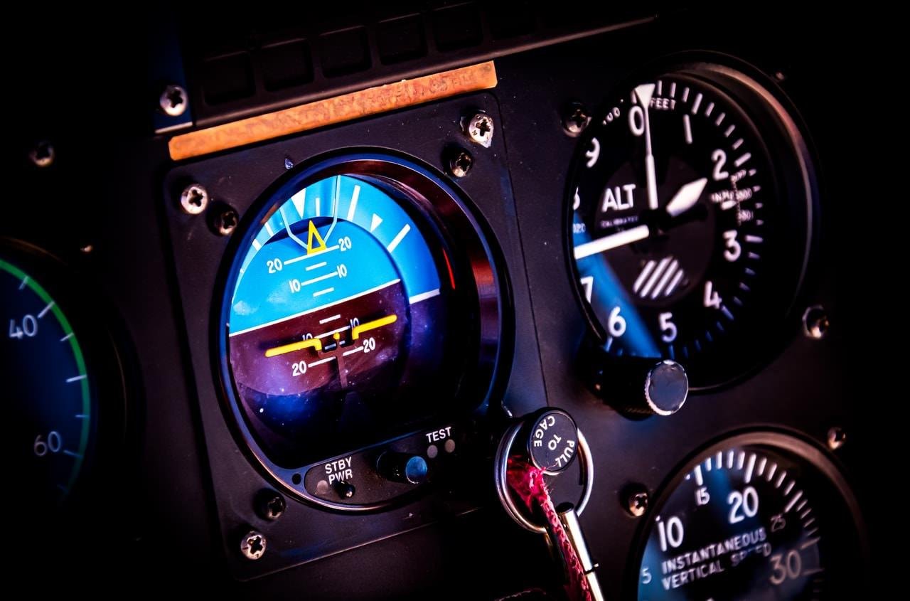 This image shows a section of an aircraft's cockpit instrument panel. It includes:

1. An attitude indicator (artificial horizon), which displays the aircraft's orientation relative to the horizon.
2. An altimeter, indicating the aircraft's altitude.
3. A vertical speed indicator, showing the rate of climb or descent.

These instruments are essential for pilots to maintain proper control and navigation of the aircraft.