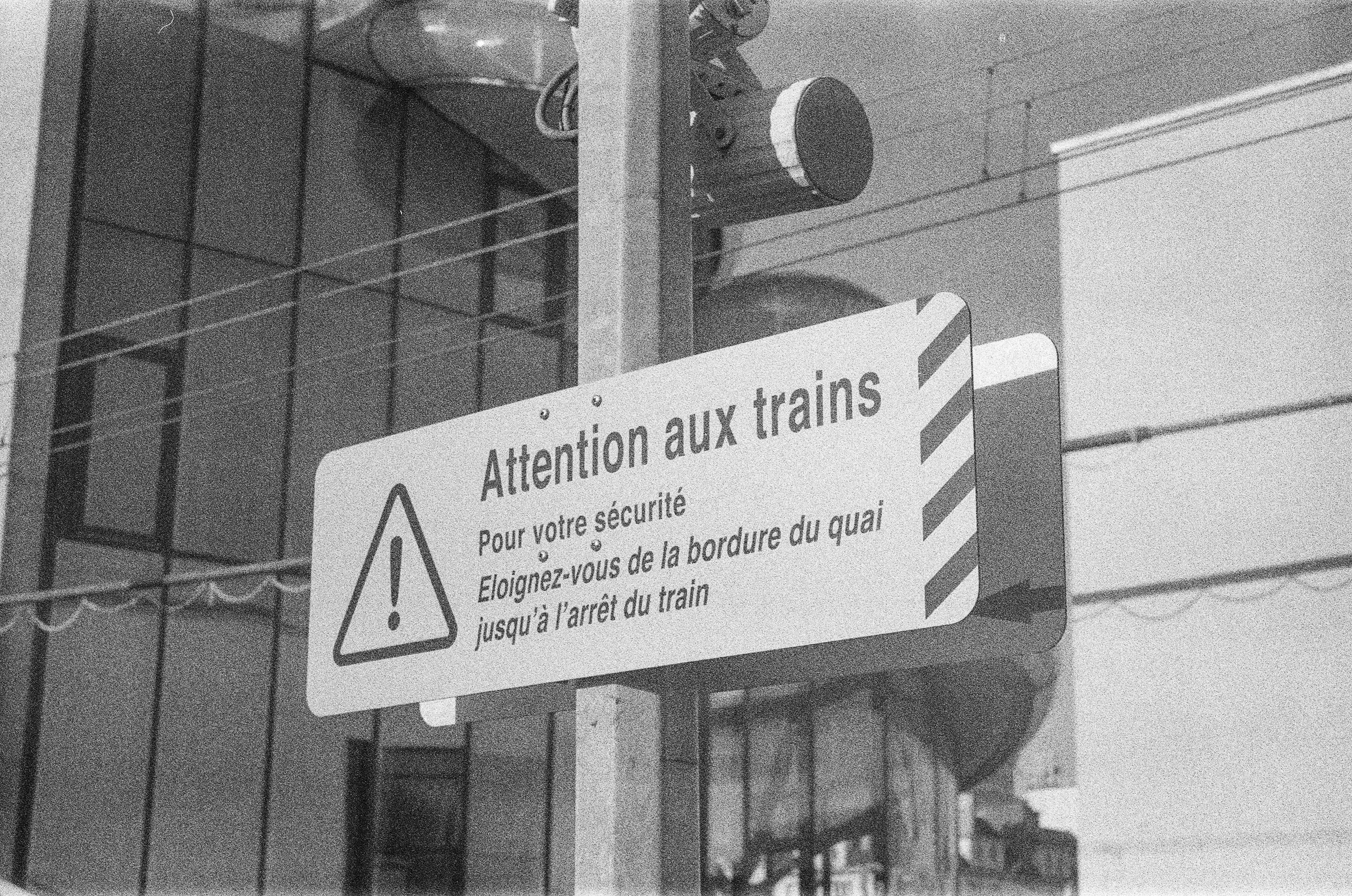 "Attention aux trains" warning sign on a train station platfrorm