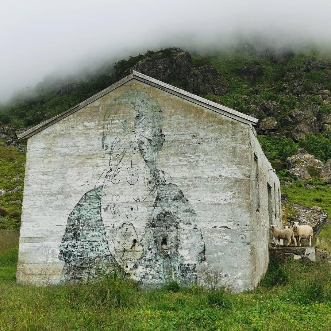 Faded graffiti of a figure wearing a scarf with teddy bears covering their face.