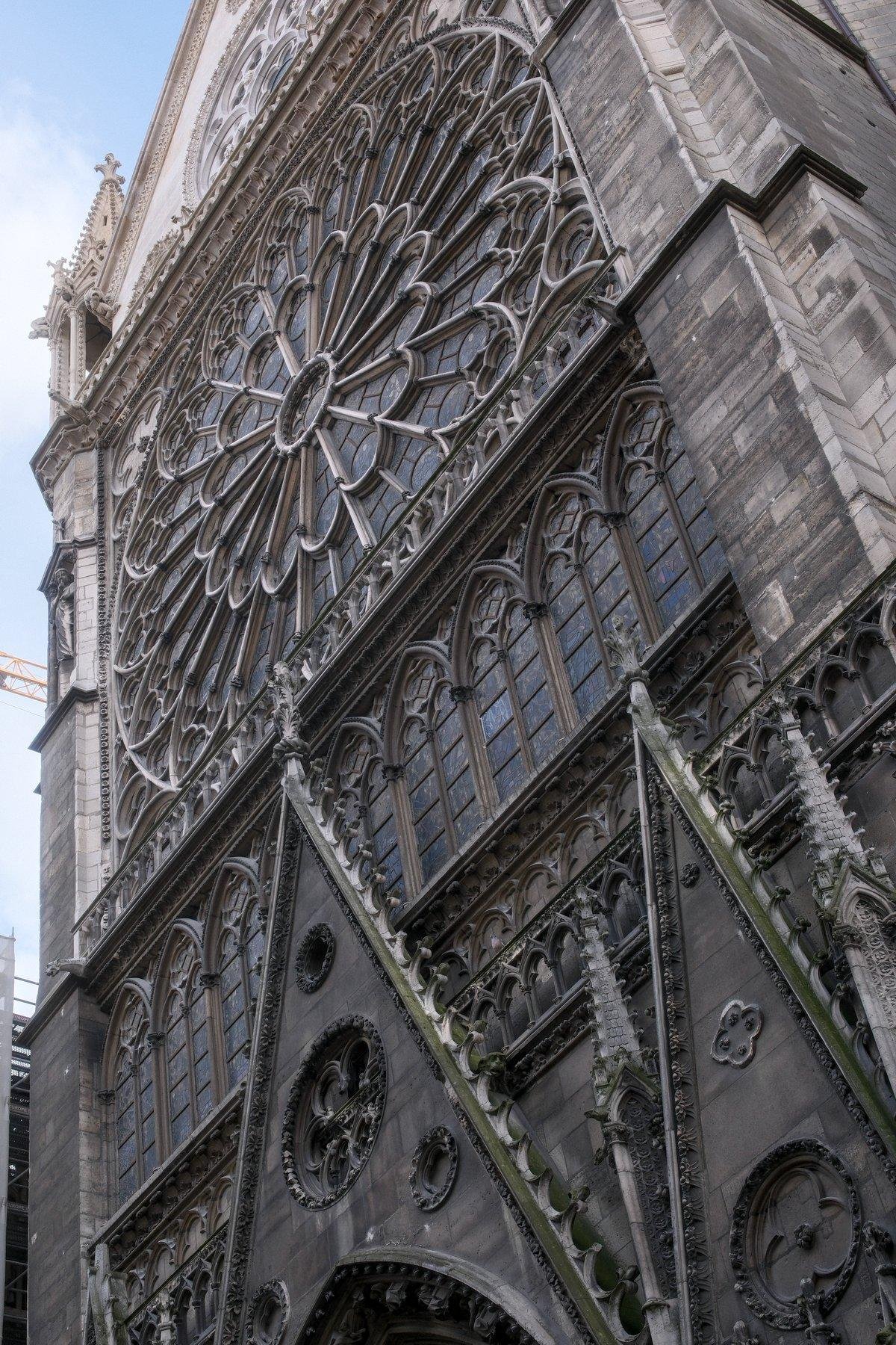 Photo verticale. Contre plongée sur la rosace d’un des côtés de Notre-Dame de Paris