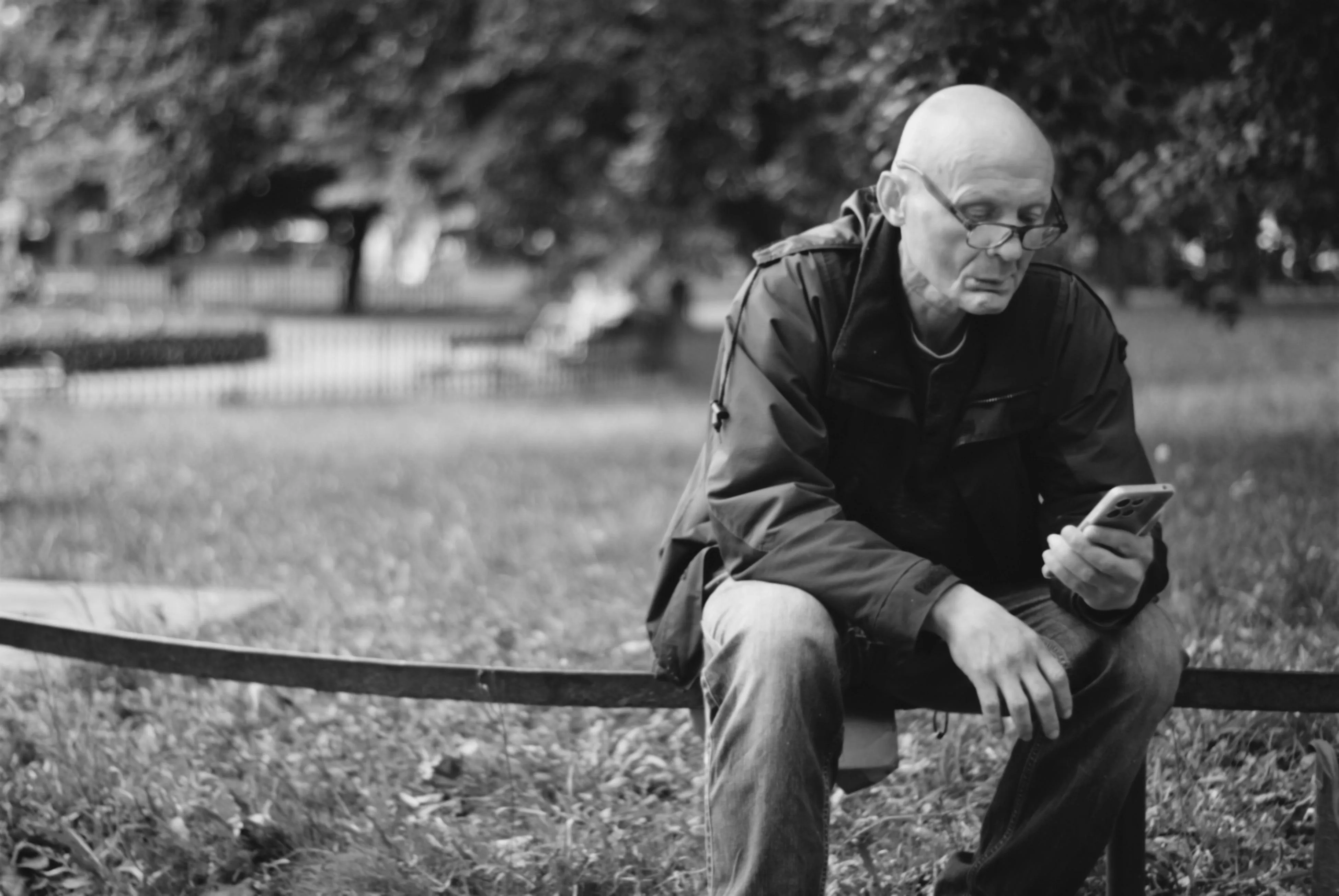 A photo of an old man looking at his phone