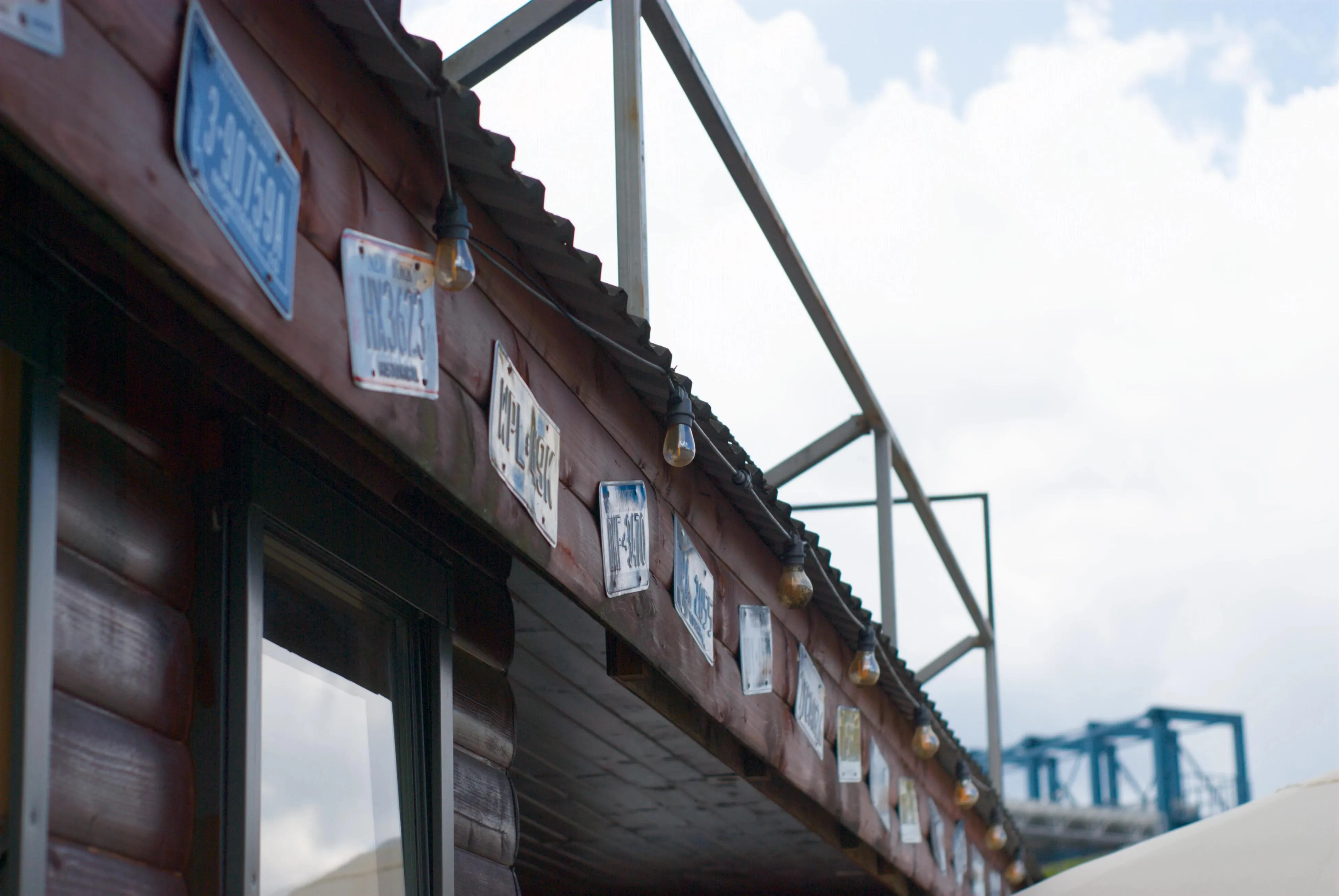 A photo of a wooden wall with various licence plates attached to it
