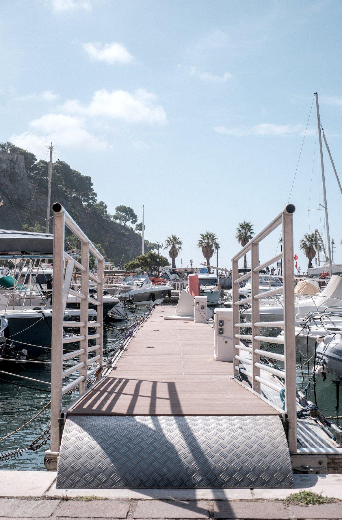 Vertical photo. Knee level view of the entry of a ramp leading to multiple parked boats
