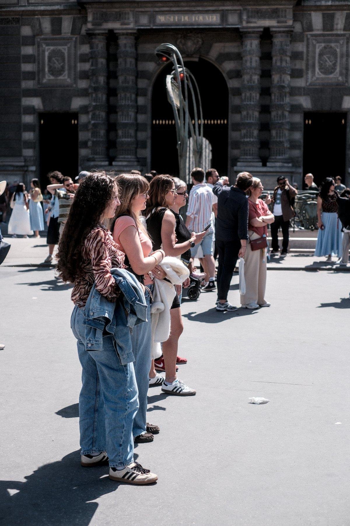 Photo verticale. Une rangée de 4 femmes faisant face à la même direction, entrain de regarder les musiciens de la 2e image