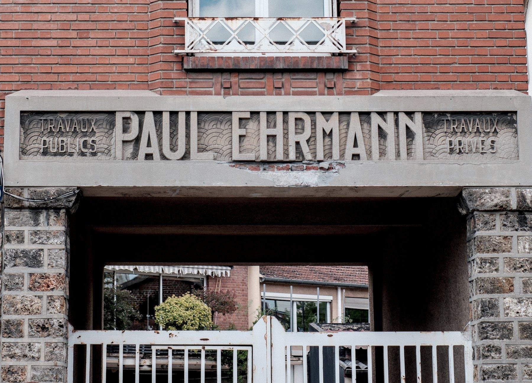 Photo horizontale. Un linteau de portail, avec gravé dans la partie horizontale, PAUL EHRMANN en police un peu art nouveau