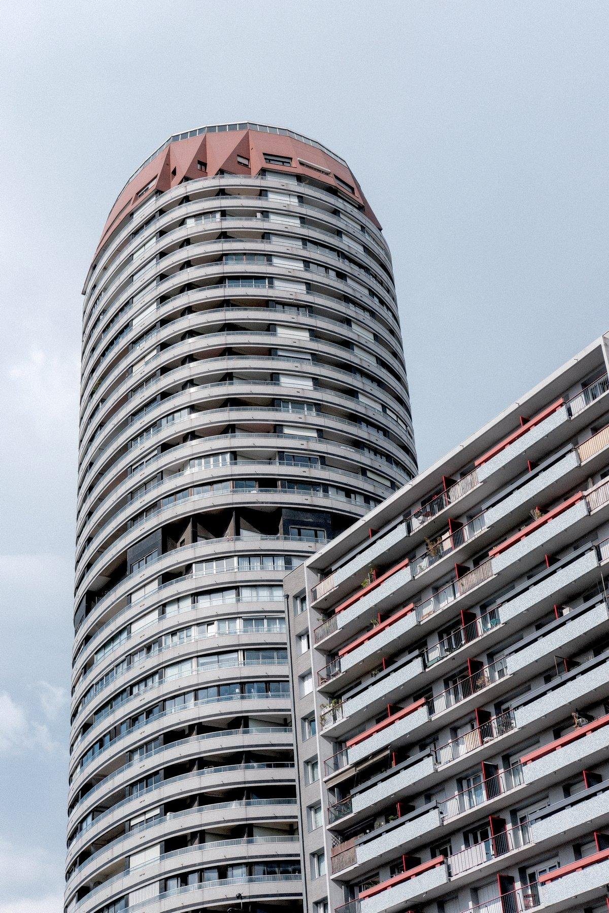 Photo verticale. Contre-plongée sur un immeuble en forme de cylindre