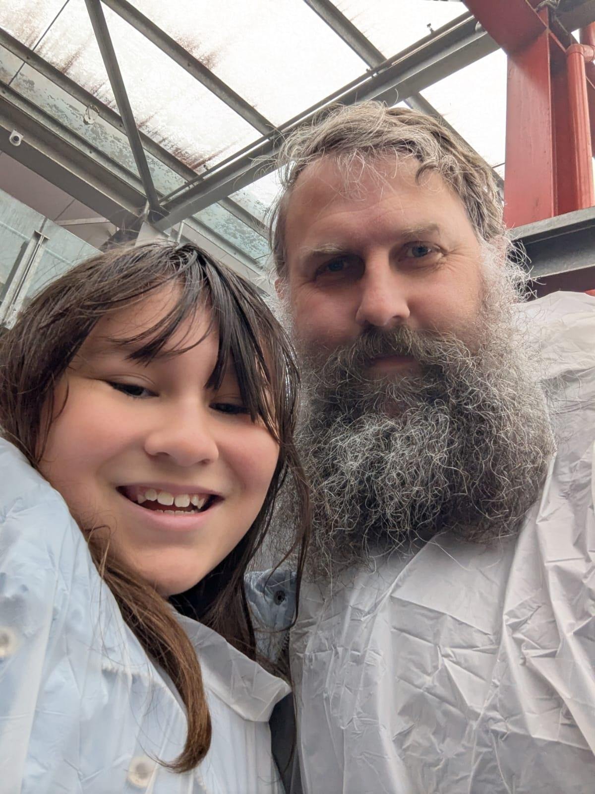 Young girl and her father in single us plastic rain coats