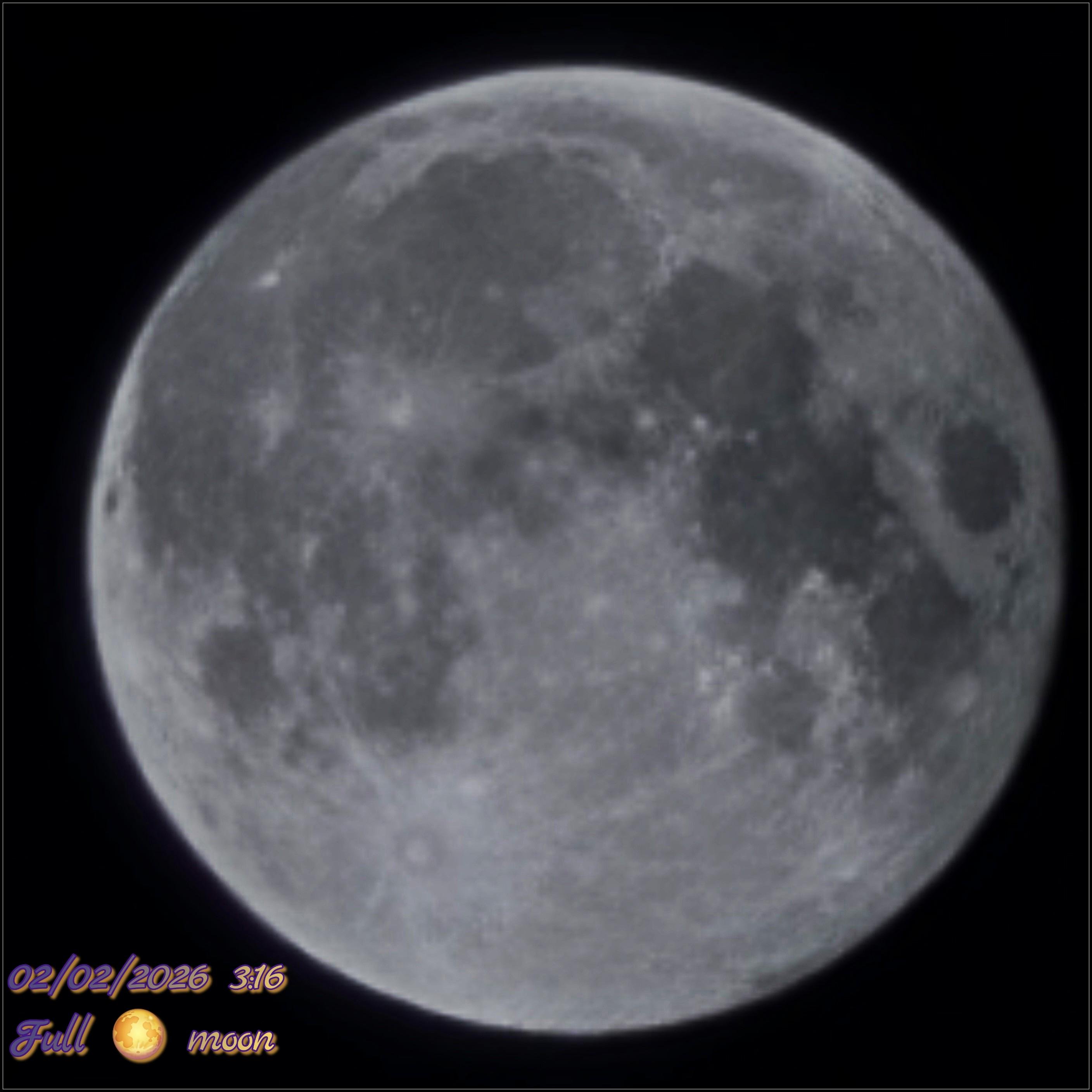 A crisp, detailed view of a full moon glowing against the deep black of space. The surface is a mix of cratered highlands and dark, smooth lunar plains, with the prominent Tycho crater’s ray system stretching out from the bottom. In the lower-left corner, stylized yellow text with a purple border marks the moment: "02/02/2026 3:16" above "Full 🌕 moon," featuring a small moon emoji. It’s a classic, atmospheric night-sky shot that captures the Moon in all its cratered, celestial glory.
