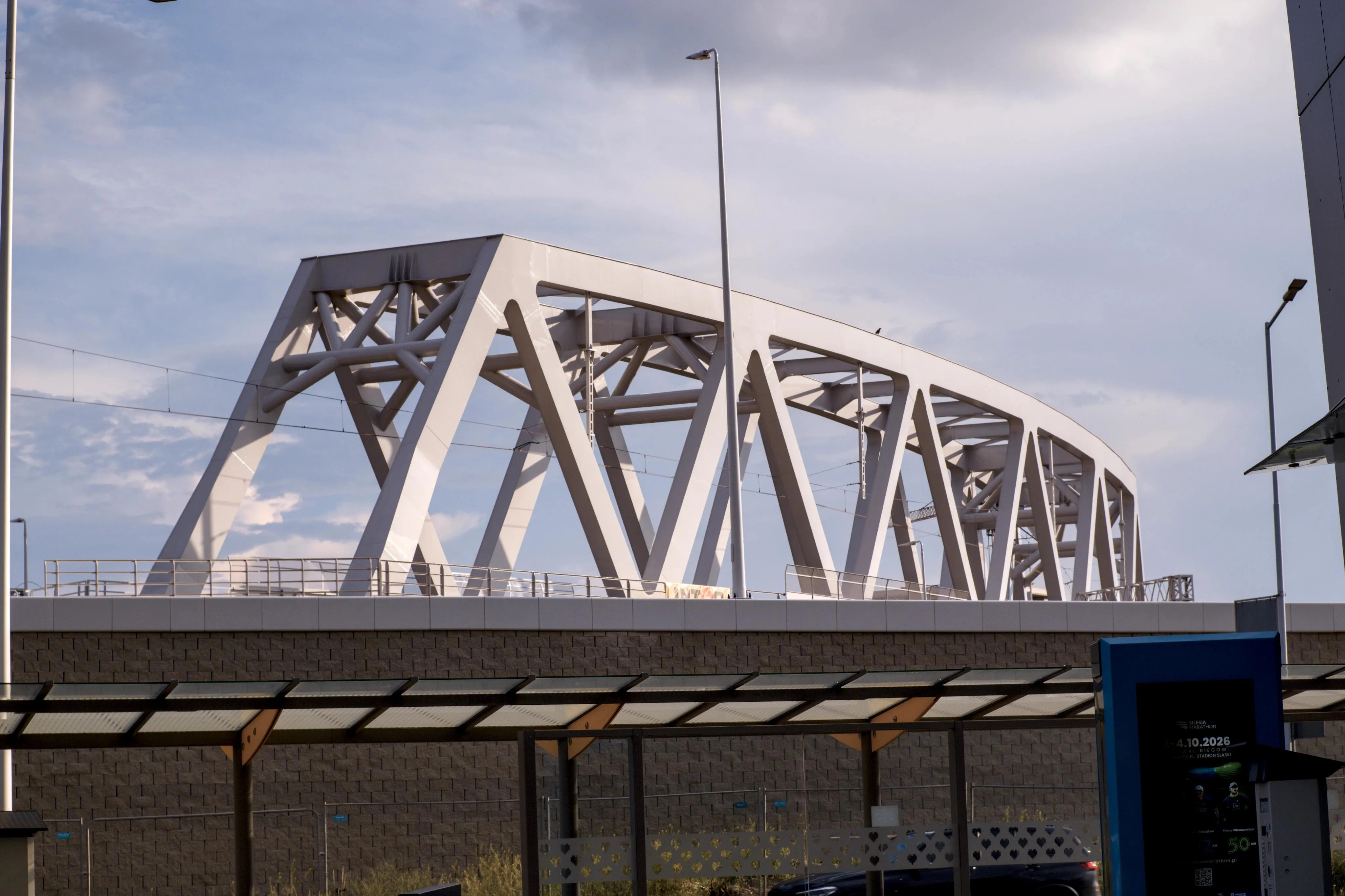A photo of a white slightly curved bridge