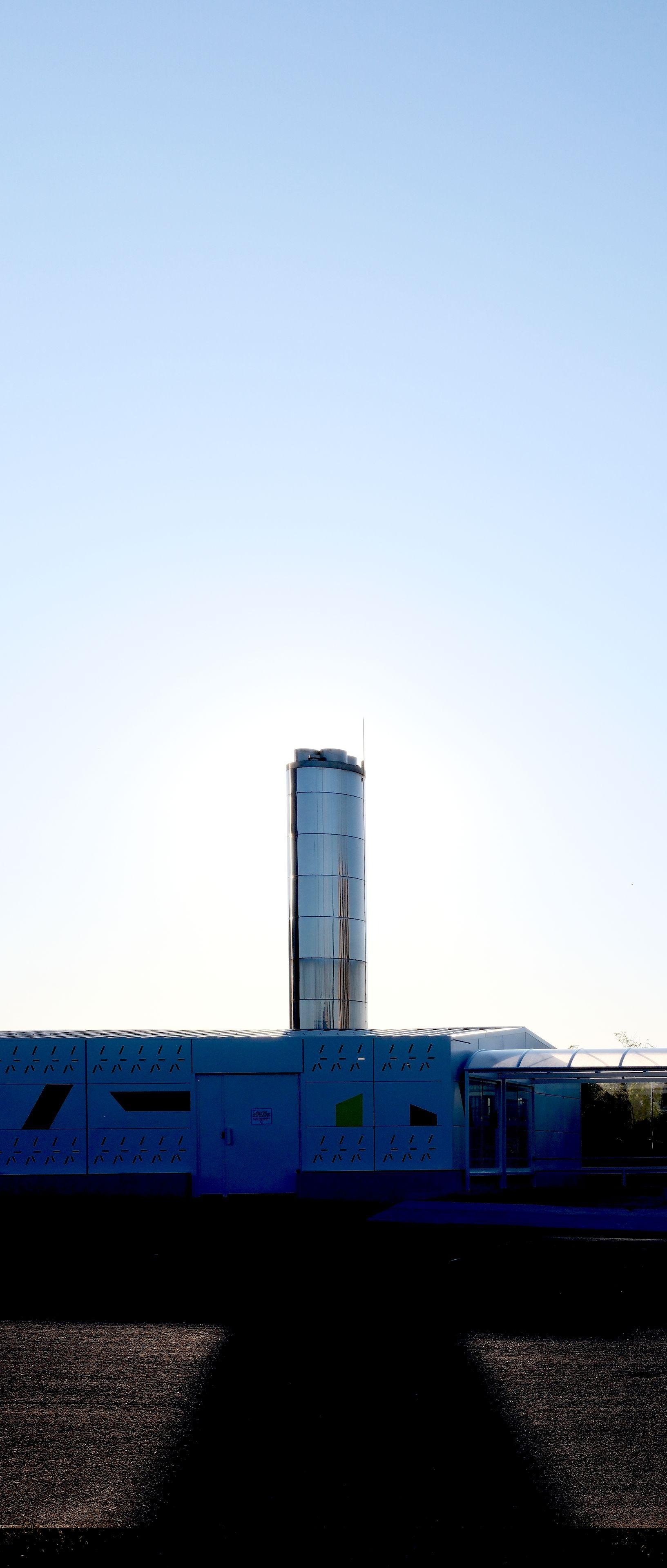 Une grosse cheminée chromée en contre jour avec le soleil pile derrière, projetant une ombre vers la caméra