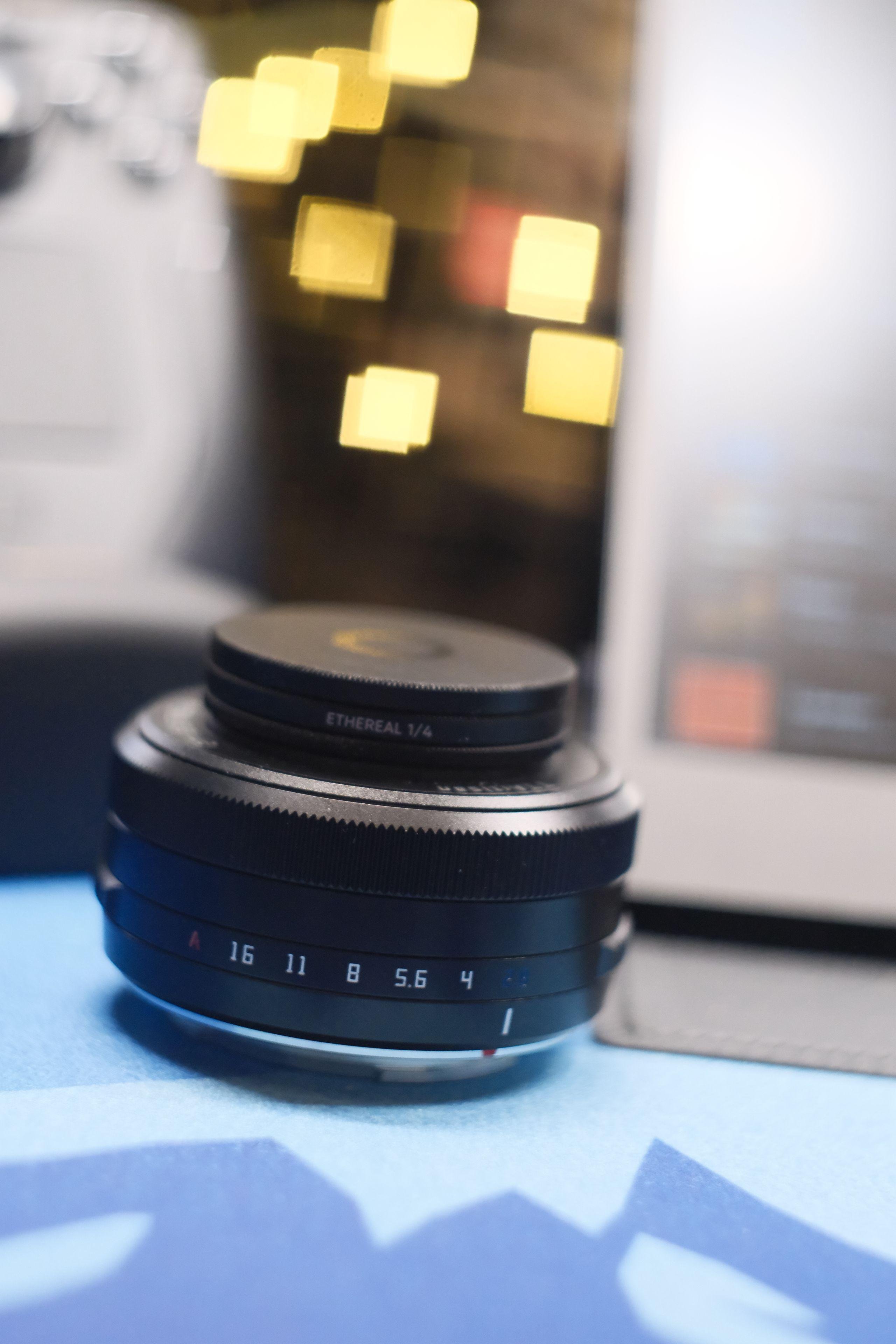 Portrait format pic with a small lens on the front and a bokeh with square spots instead of circles ones
