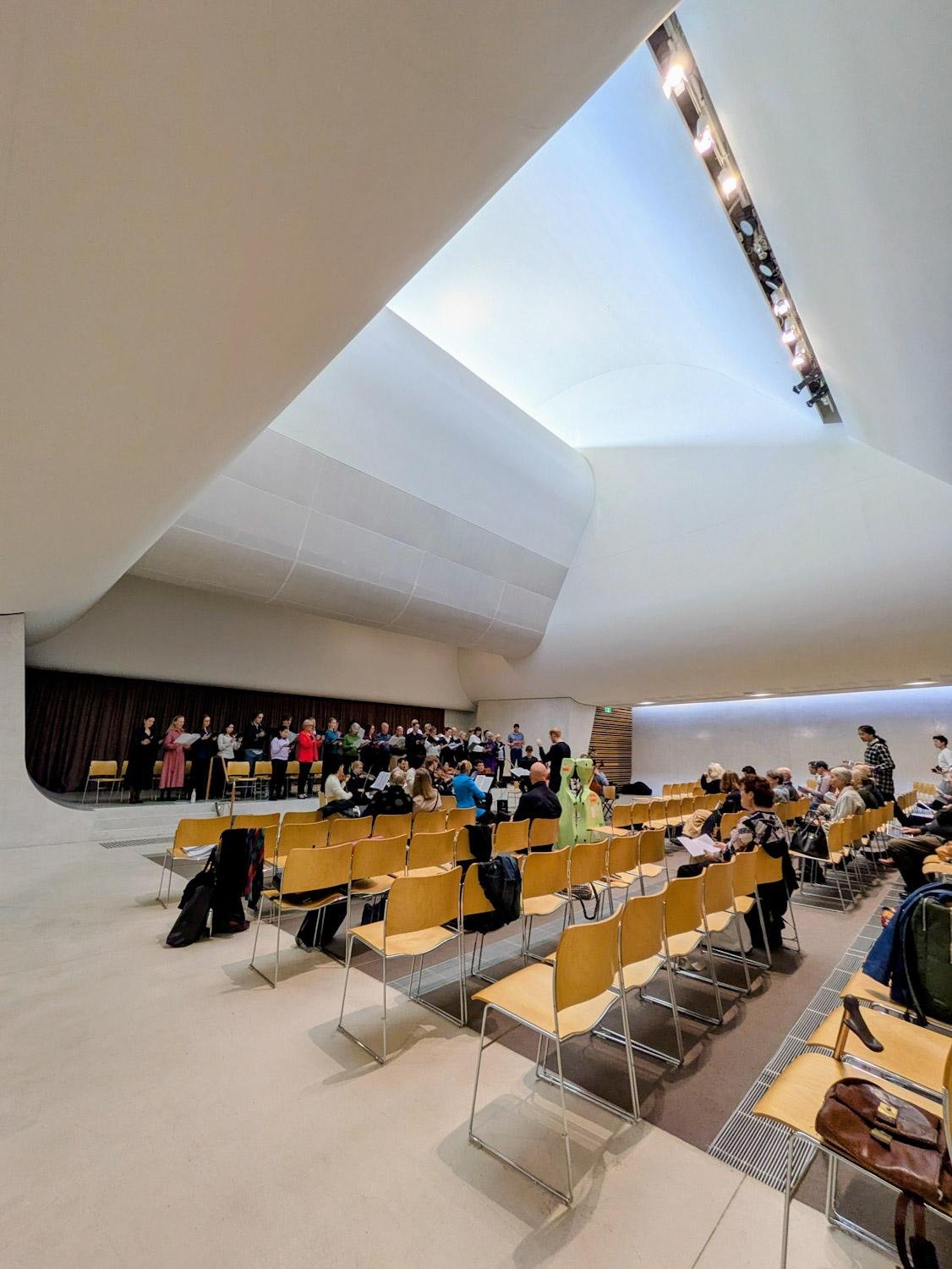 Choir and orchestra rehearsing bach cantata in modern church.