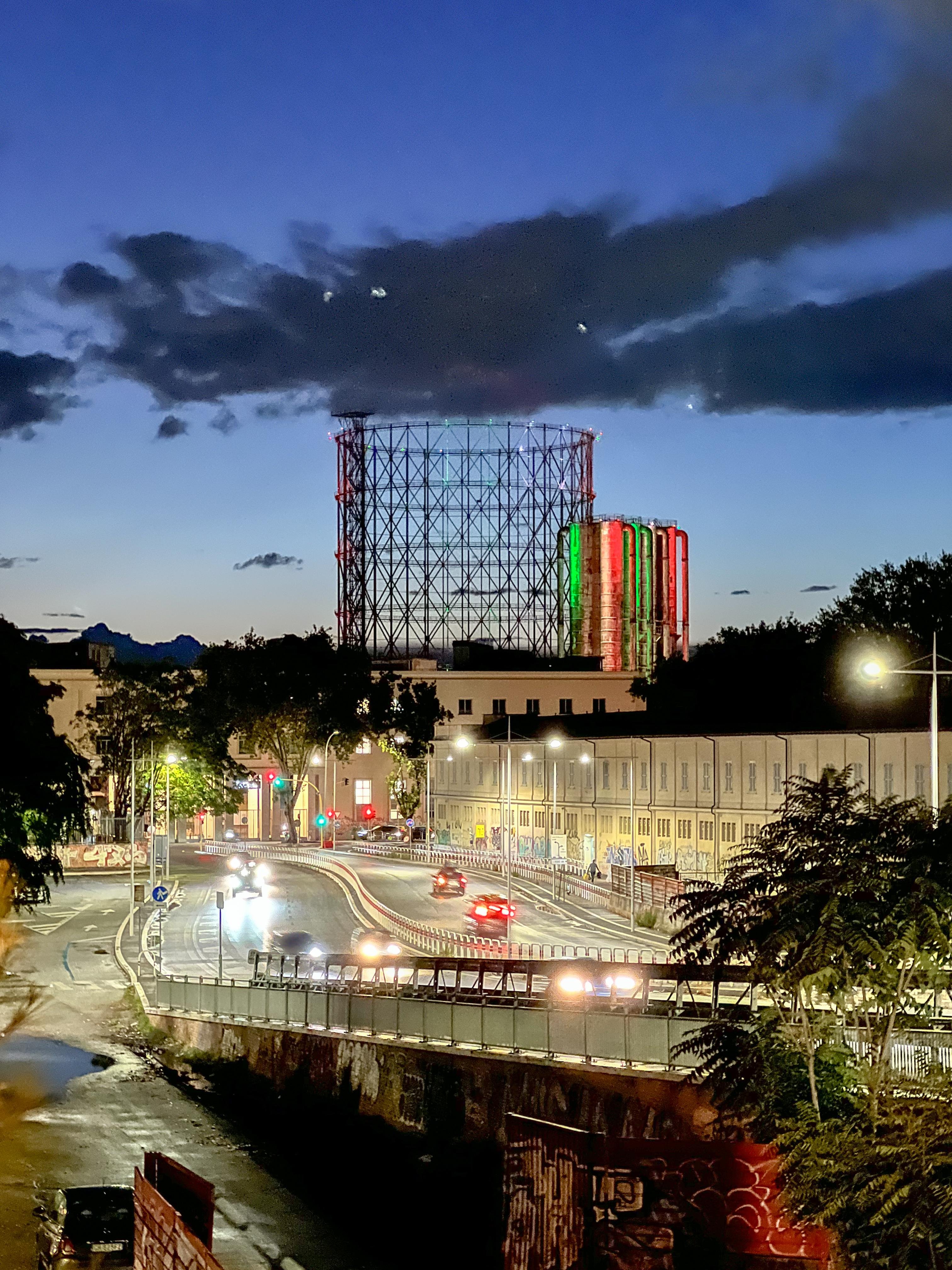 Immagine notturna della Circonvallazione Ostiense a Roma con il Gasometro sullo sfondo.