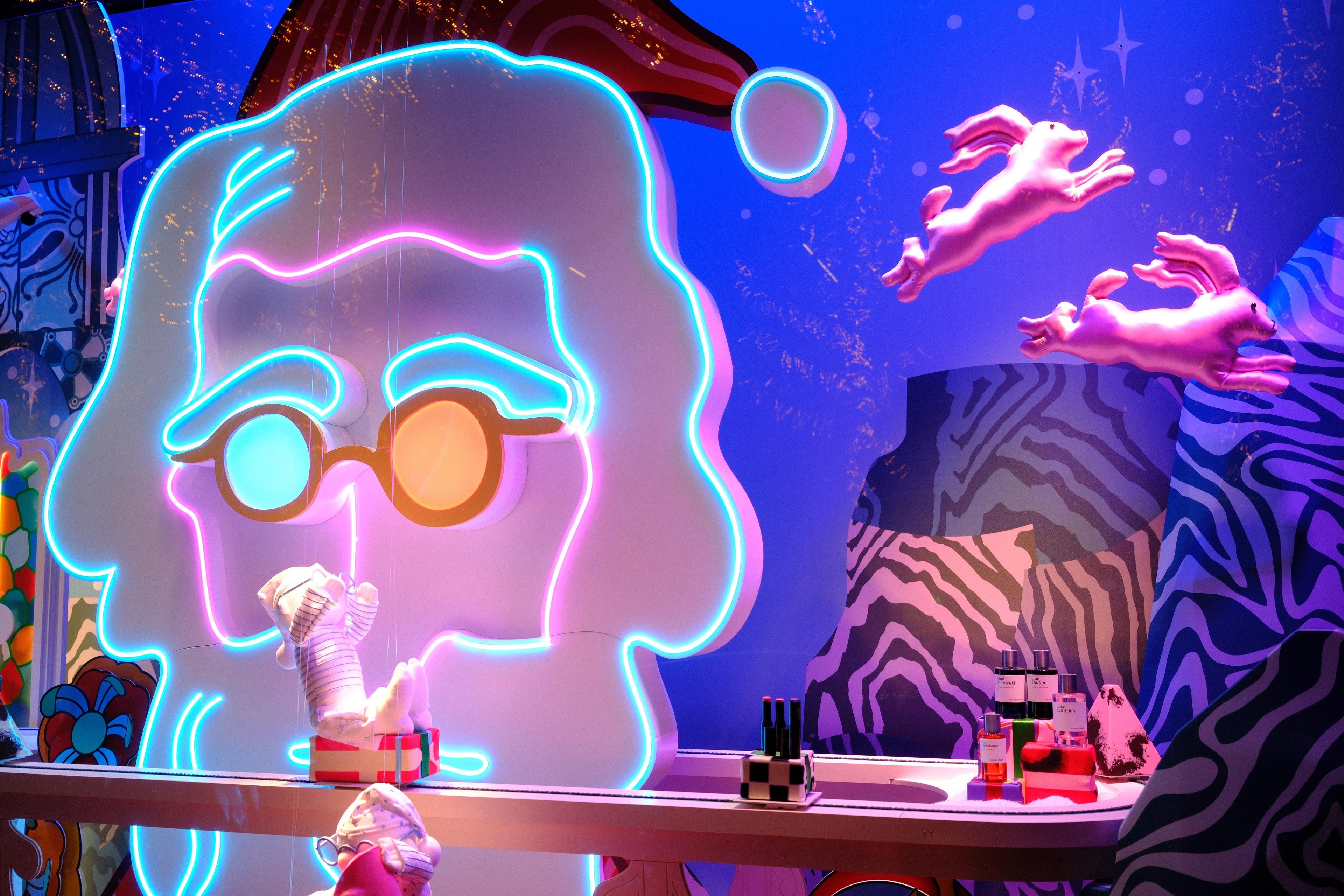 Photo horizontale. Vitrine de Noël avec une tête stylisée de père noël en néon, avec des lunettes rondes, me faisant penser à John Lennon