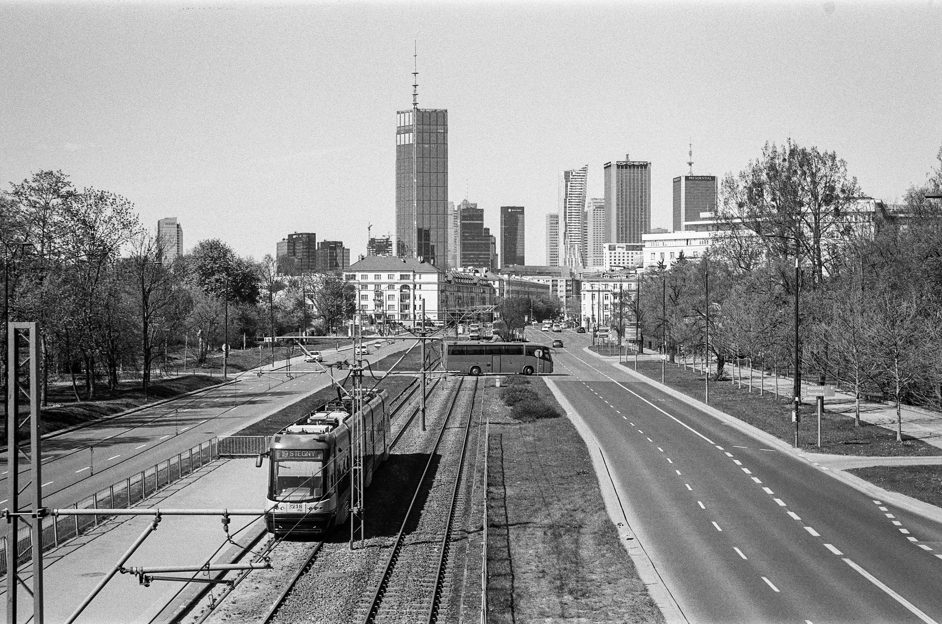 B&W film photo of a tram approaching National Library stop, Warsaw. Skyline of the city center in the background