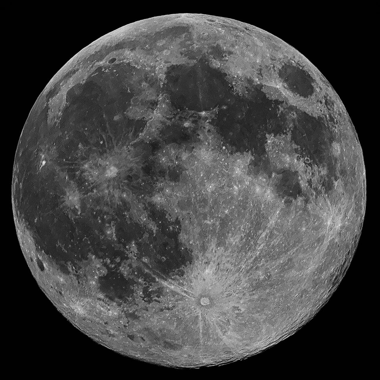 Full moon against a black background. Surface details include prominent craters and dark maria regions, with visible rays emanating from a central crater at the bottom.
