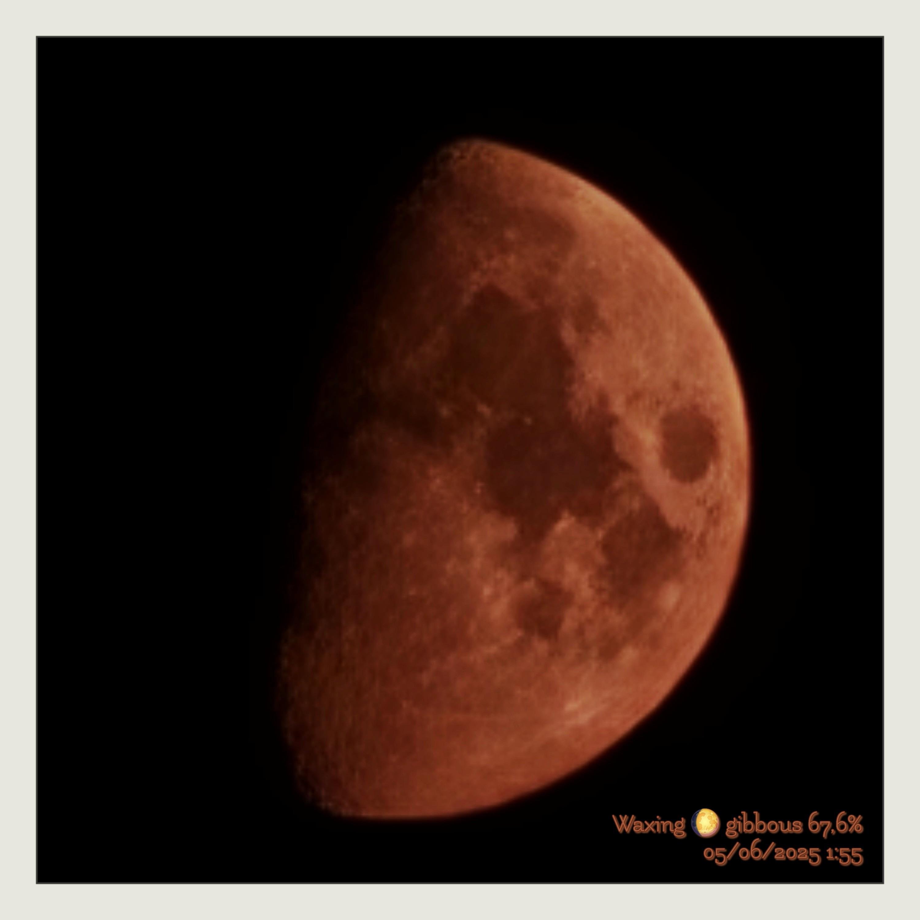 A close-up photograph of the Moon fills most of the frame, set against a pitch-black night sky. The Moon appears in a warm reddish-brown tone, as captured directly through the camera without digital processing of the lunar surface. It is shown in its waxing gibbous phase, with the right side brightly illuminated and the left side fading softly into shadow. Numerous craters and mare regions are visible, including a prominent circular crater on the upper right side and textured, mottled patterns across the lunar surface. A thin light-gray border surrounds the image. In the bottom right corner, small stylized text in warm orange reads: “Waxing 🌕 gibbous 67,6%” on the first line, and “05/06/2025 1:55” on the second line.