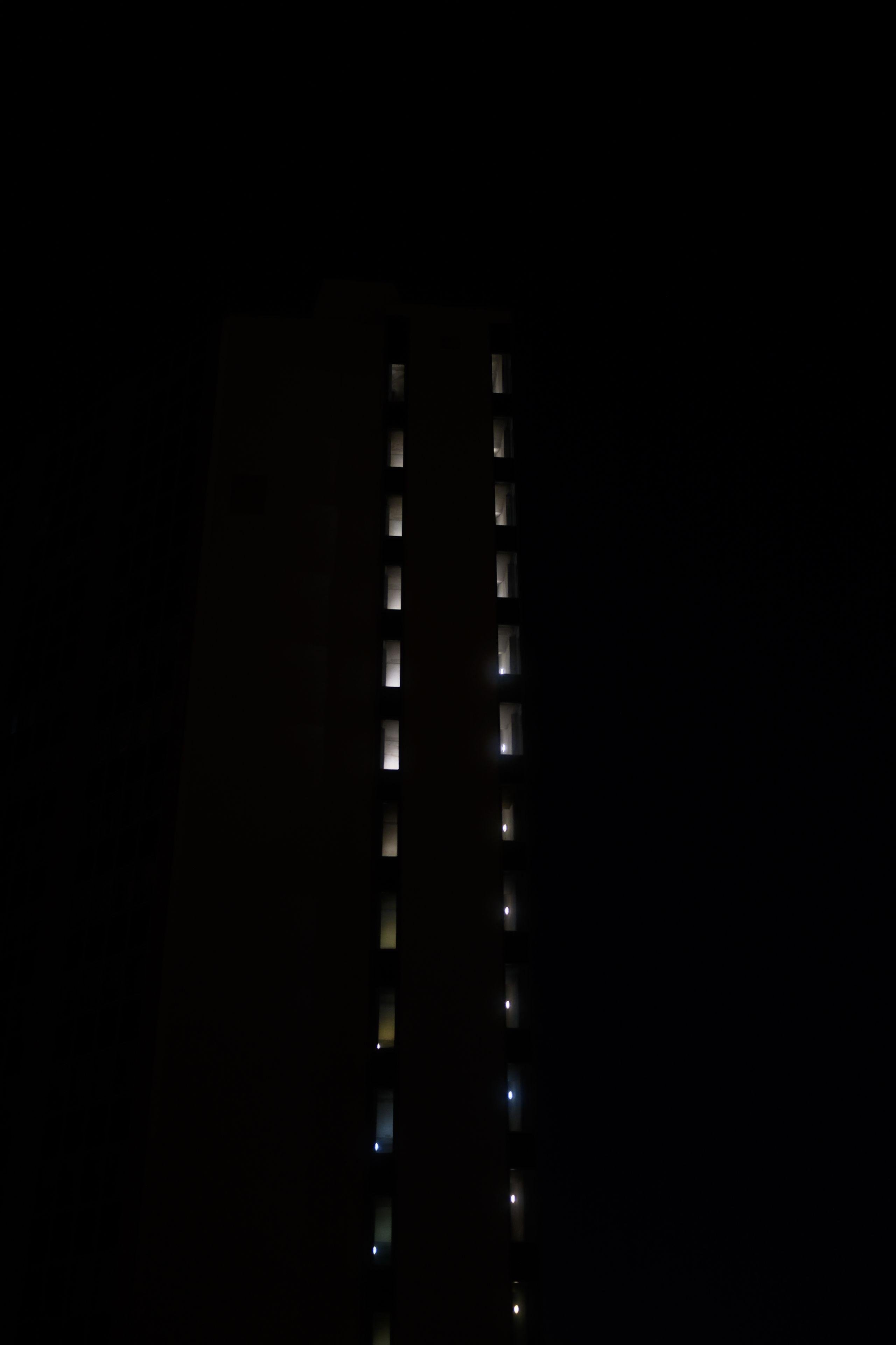 Photo de nuit, abstraite, avec deux colonnes de fenêtres d’où émane de la lumière, faisant penser à une piste de décollage