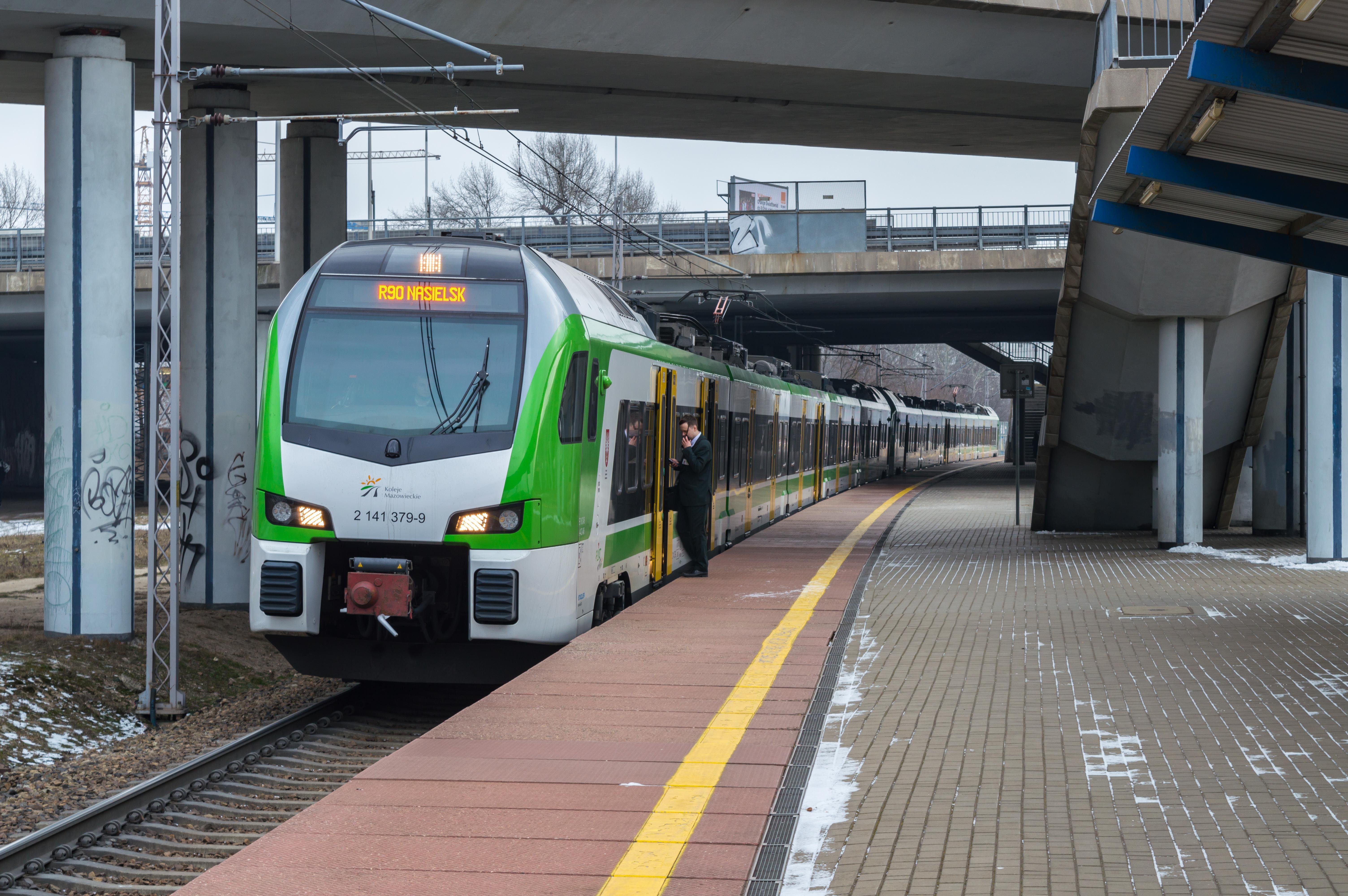 Koleje Mazowieckie R90 train running with a Stadler Flirt3 EMU right before departure from Warszawa Toruńska stop. Train manager walks through the door while announcing the departure on the radio