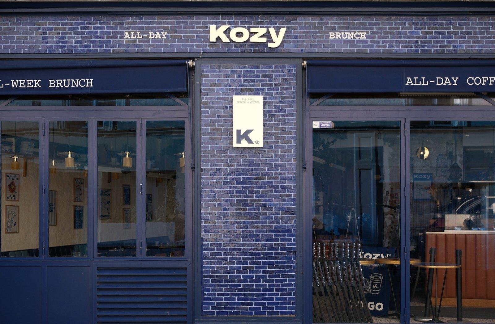 La façade très bleue en tuiles de carrelage rectangulaires d’un bar nommé «&nbsp;Kozy&nbsp;»