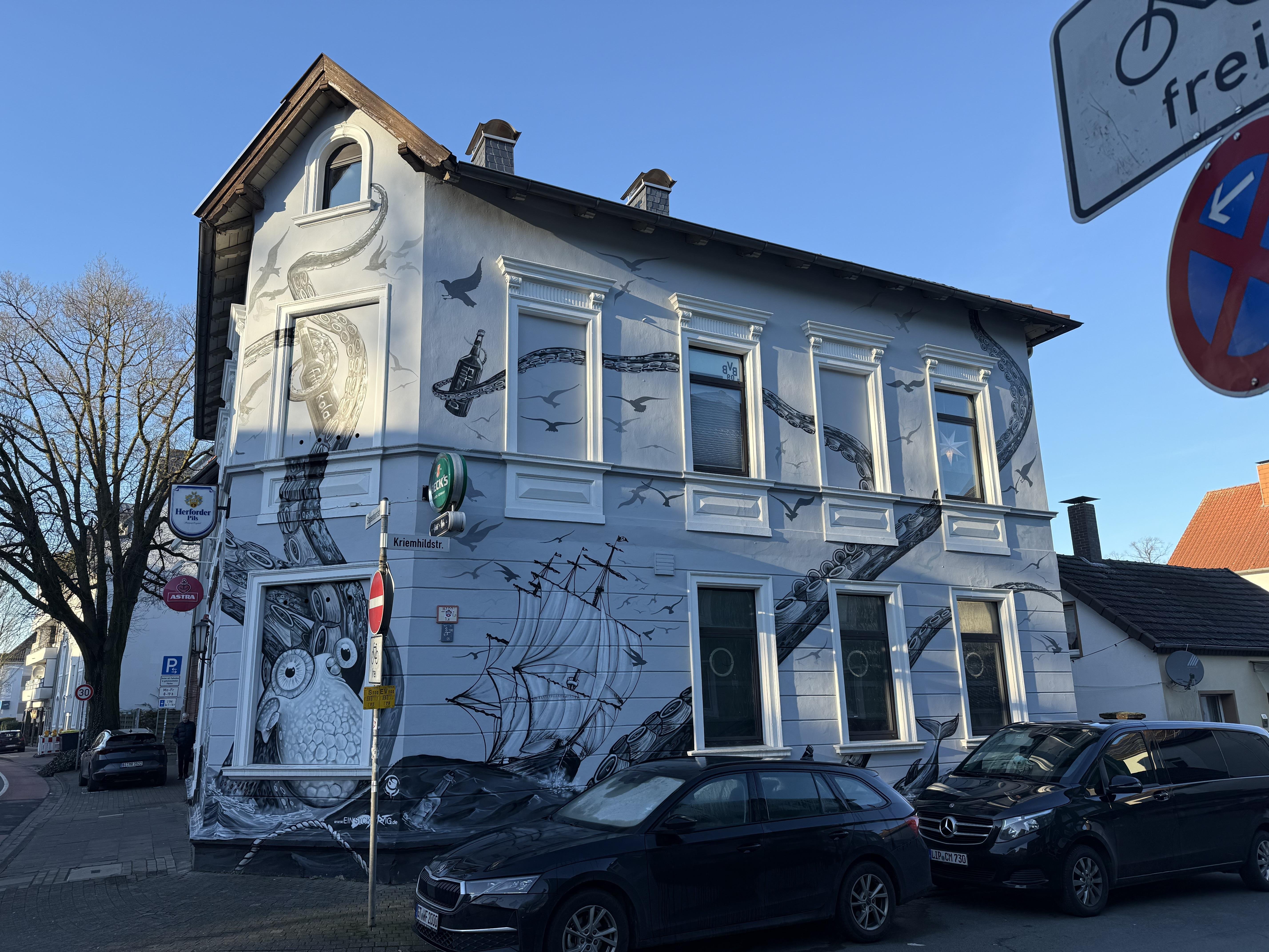 Die mit Kraken-Grafitti bemalte Bar Heimat+Hafen in Bielefeld. Außenansicht bei Tageslicht.