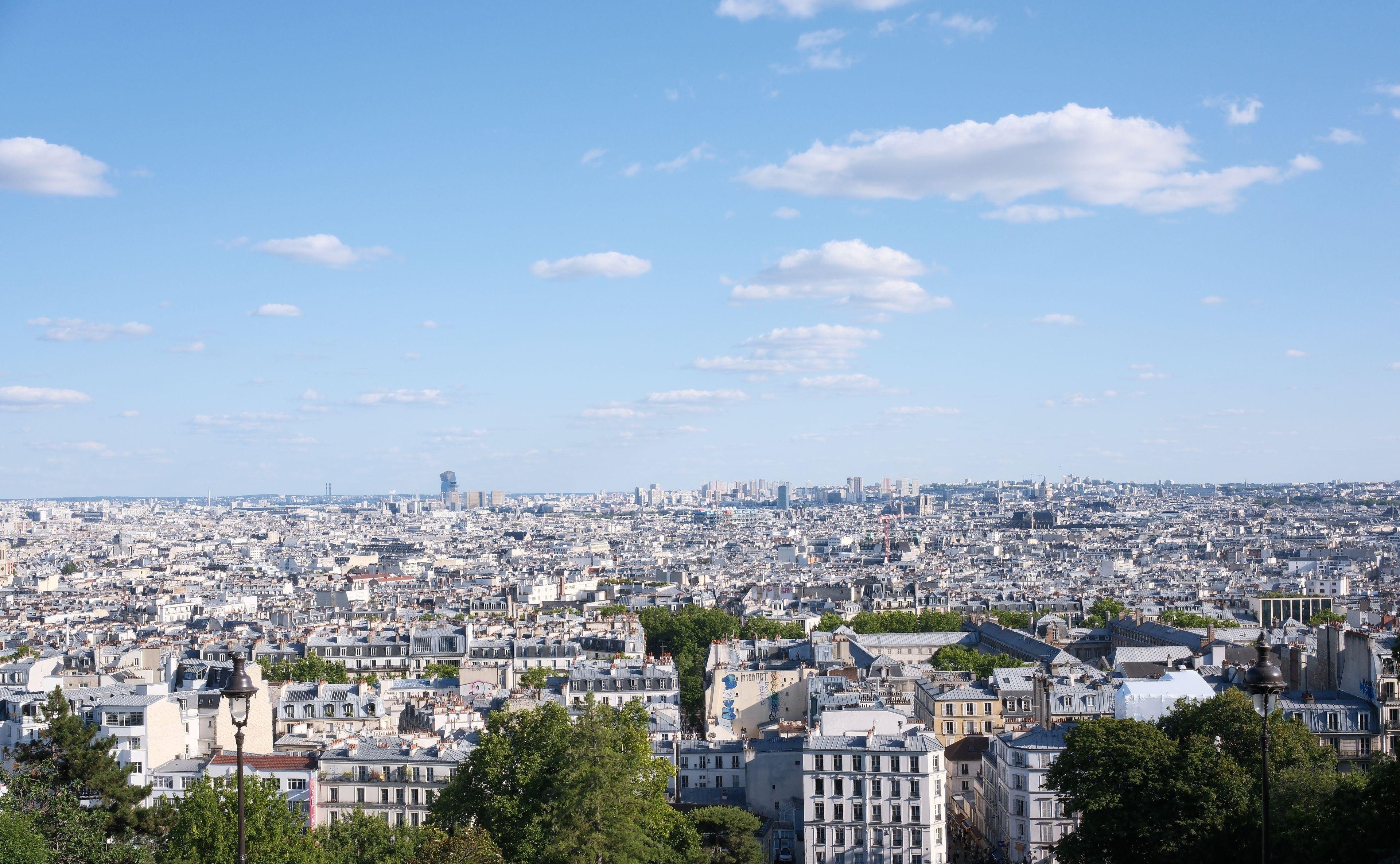 a view of Paris from the high point of view of Montmartre, under a blue sky