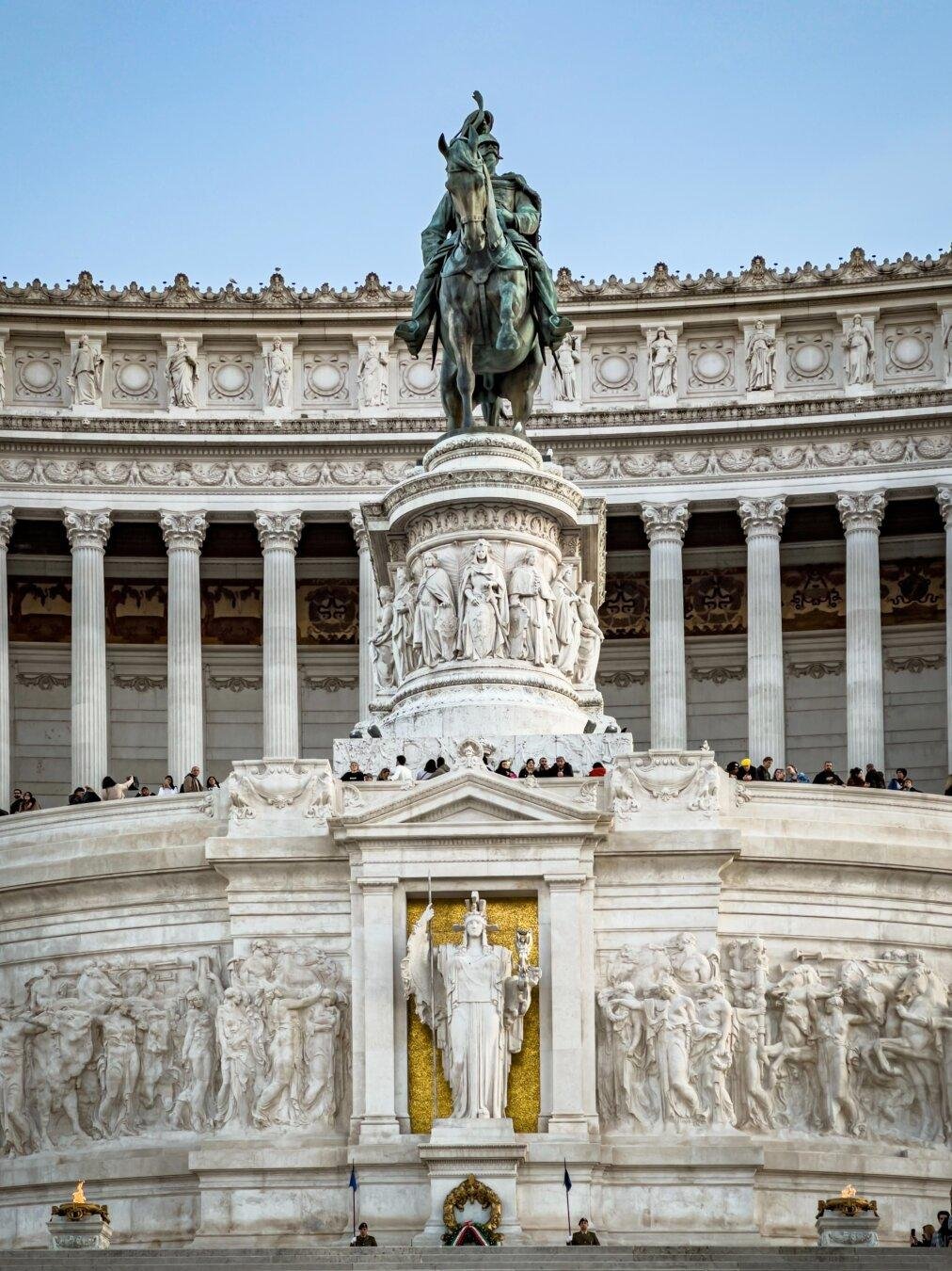 Altare della Patria, noto anche come il Monumento a Vittorio Emanuele II, situato a Roma, Italia. Il monumento è dedicato a Vittorio Emanuele II, il primo re di un’Italia unificata. Presenta una grande statua equestre di Vittorio Emanuele II al centro, circondata da dettagli architettonici intricati e sculture, tra cui una prominente statua della dea Roma sottostante.