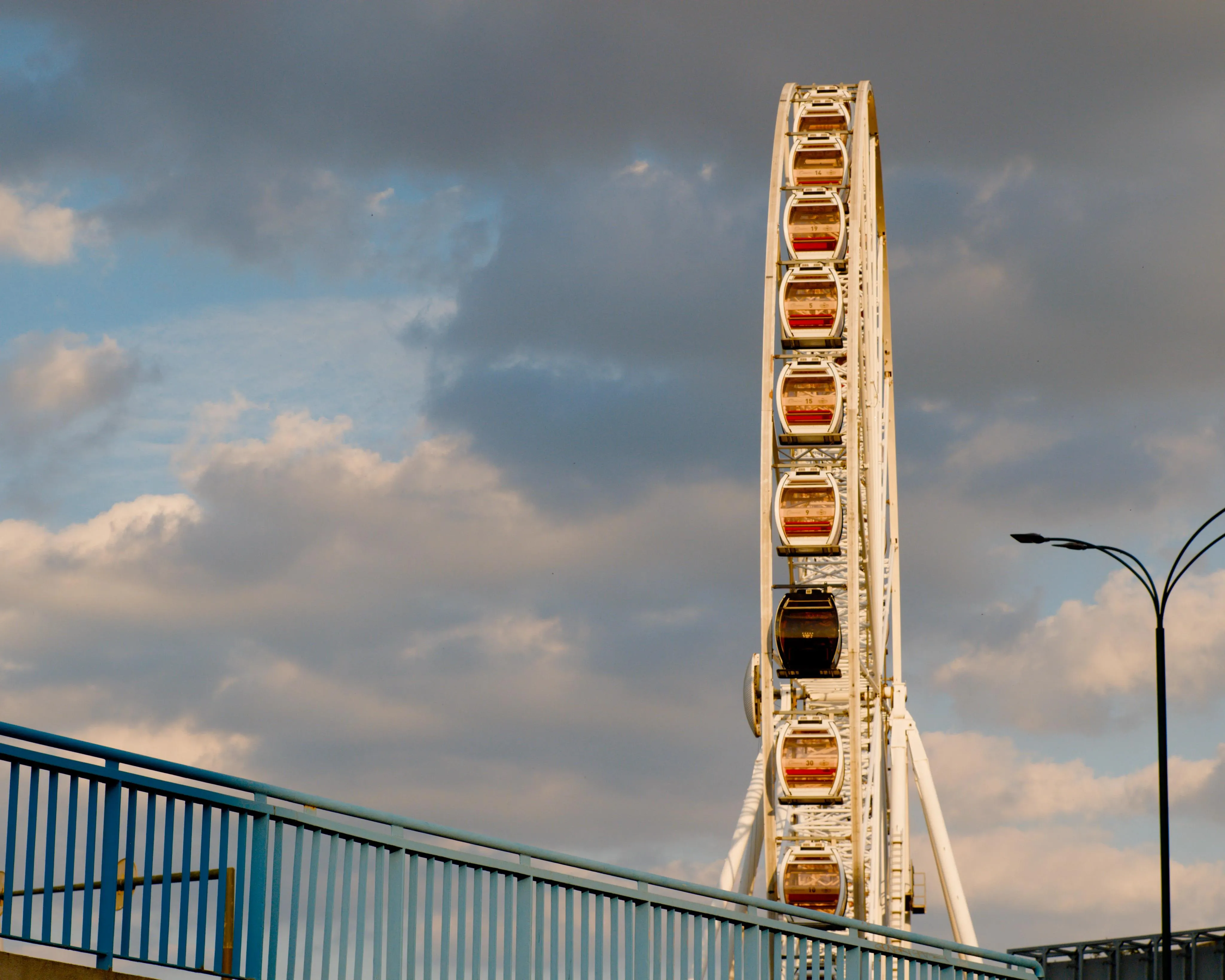 A photo of a Ferris Wheel with clouds in the background