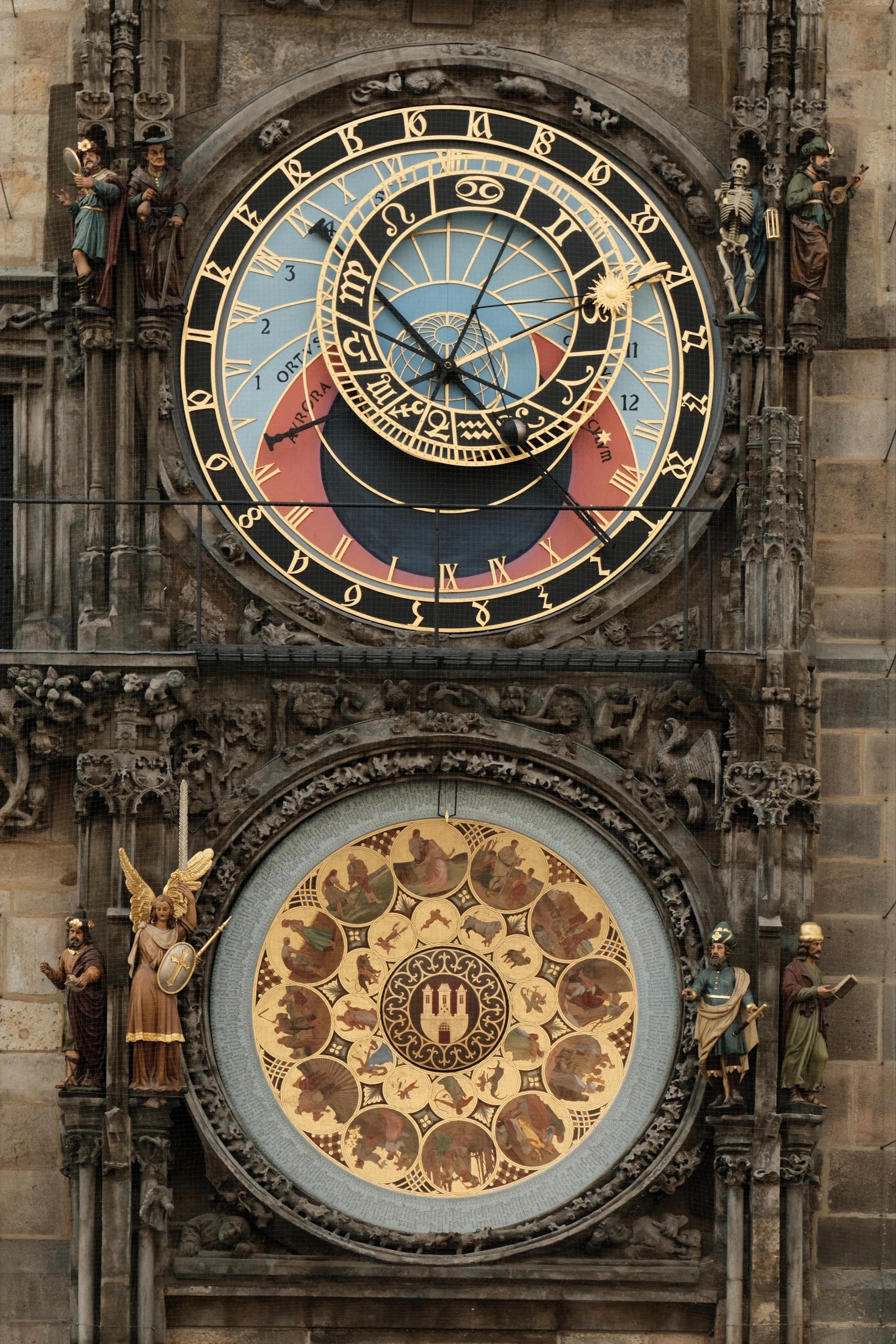 A close up view of the Prague astronomical clock. There are two dials above each other. The upper, astronomical dial shows time, solar and lunar states. The lower dial is a calendar.