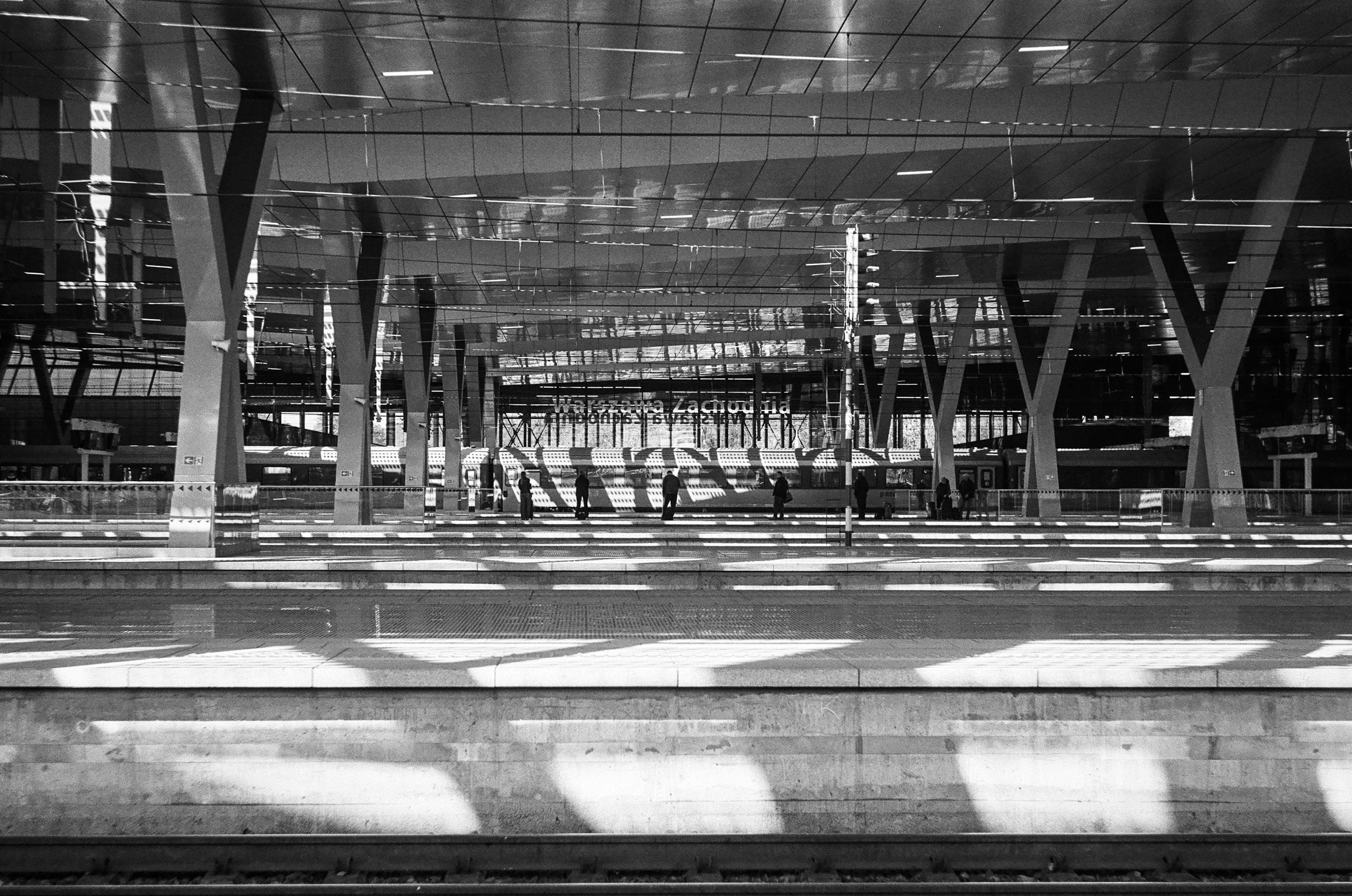 Grainy B&W film photo of platforms at Warsaw West station on a sunny day