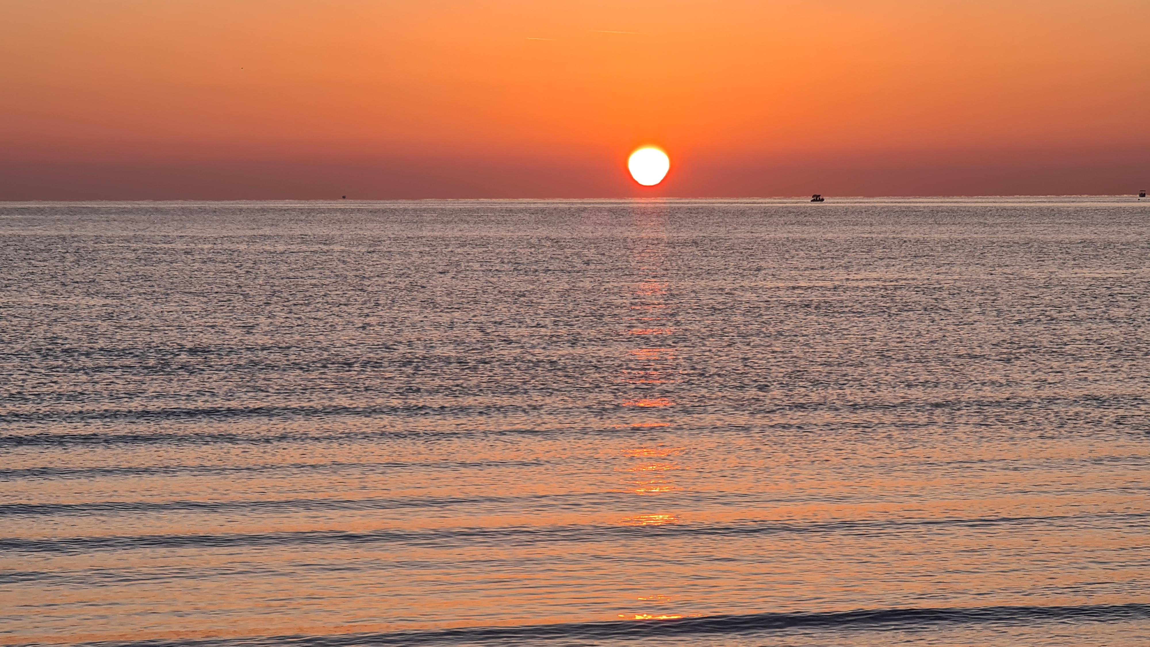 Alba in adriatico...

The image shows a serene sea view at either sunrise, with the sun low on the horizon and its reflection shimmering on the water. The sky is filled with warm tones of orange and red.
