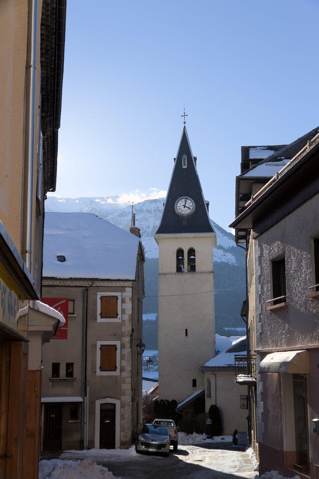 Photo d’une rue d’un petit village de montagne avec vue sur le clocher